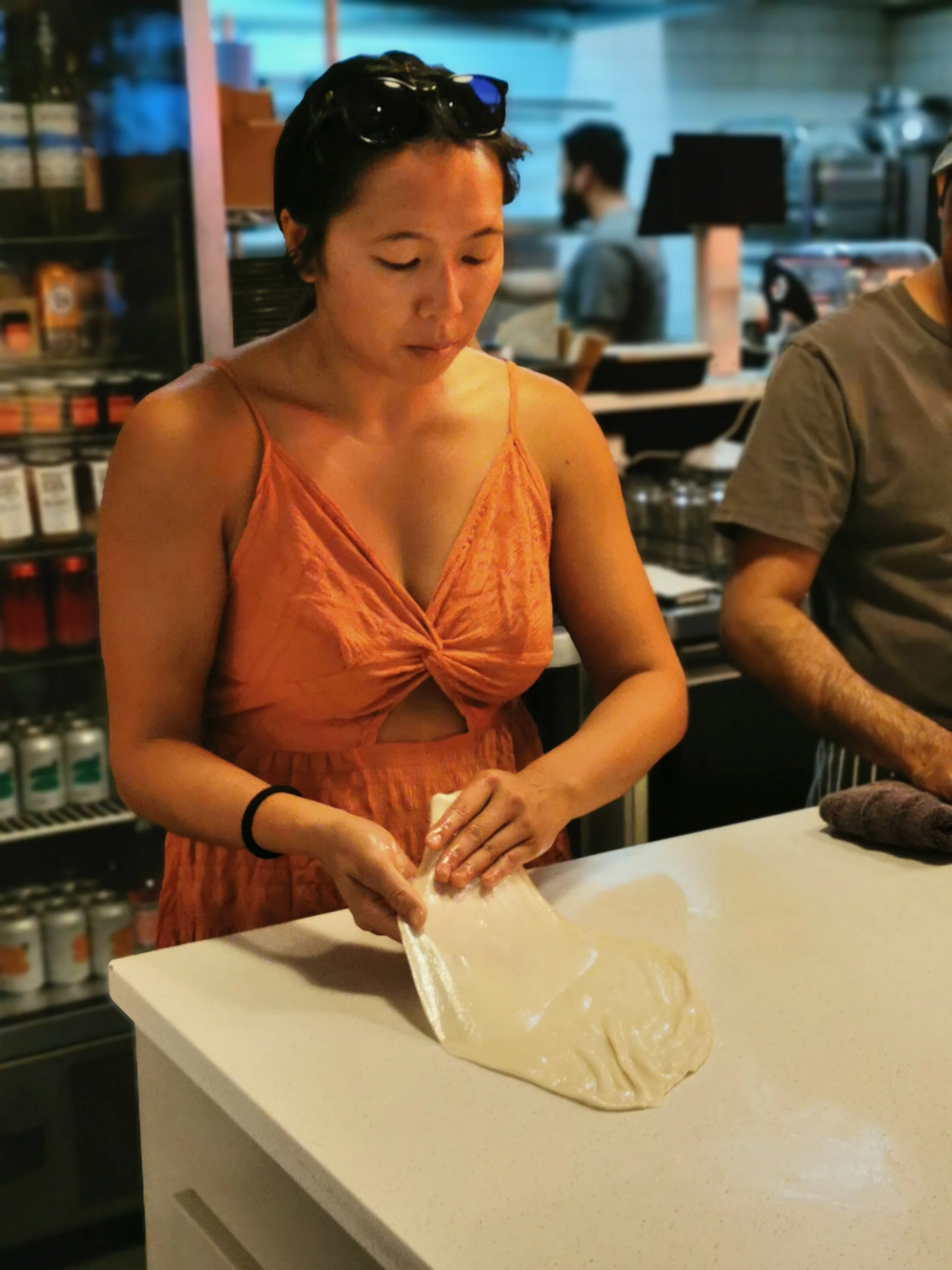 Hands stretching roti dough over the bench at Kafe Kooks