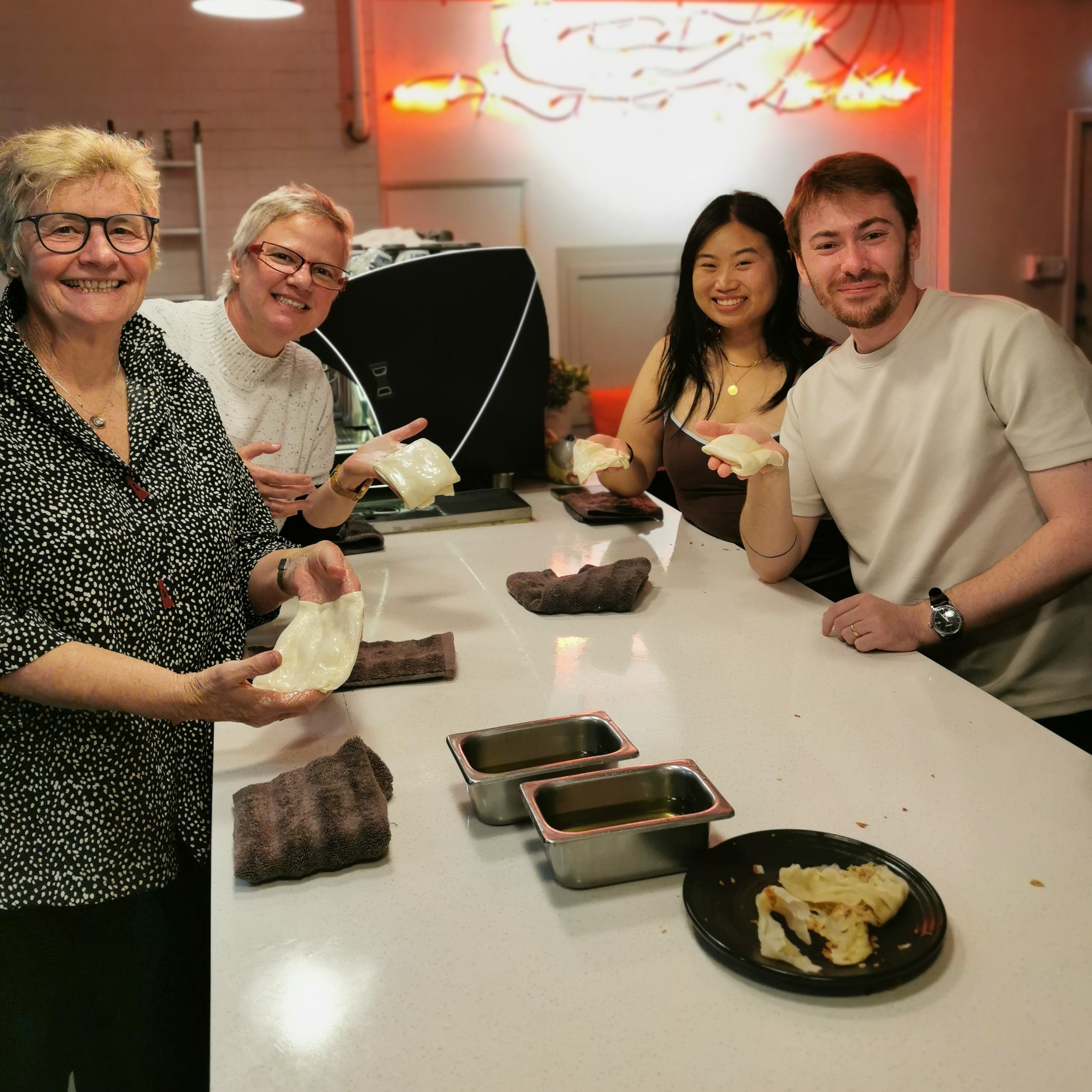 Guests smiling with their roti creation at Kafe Kooks Masterclass