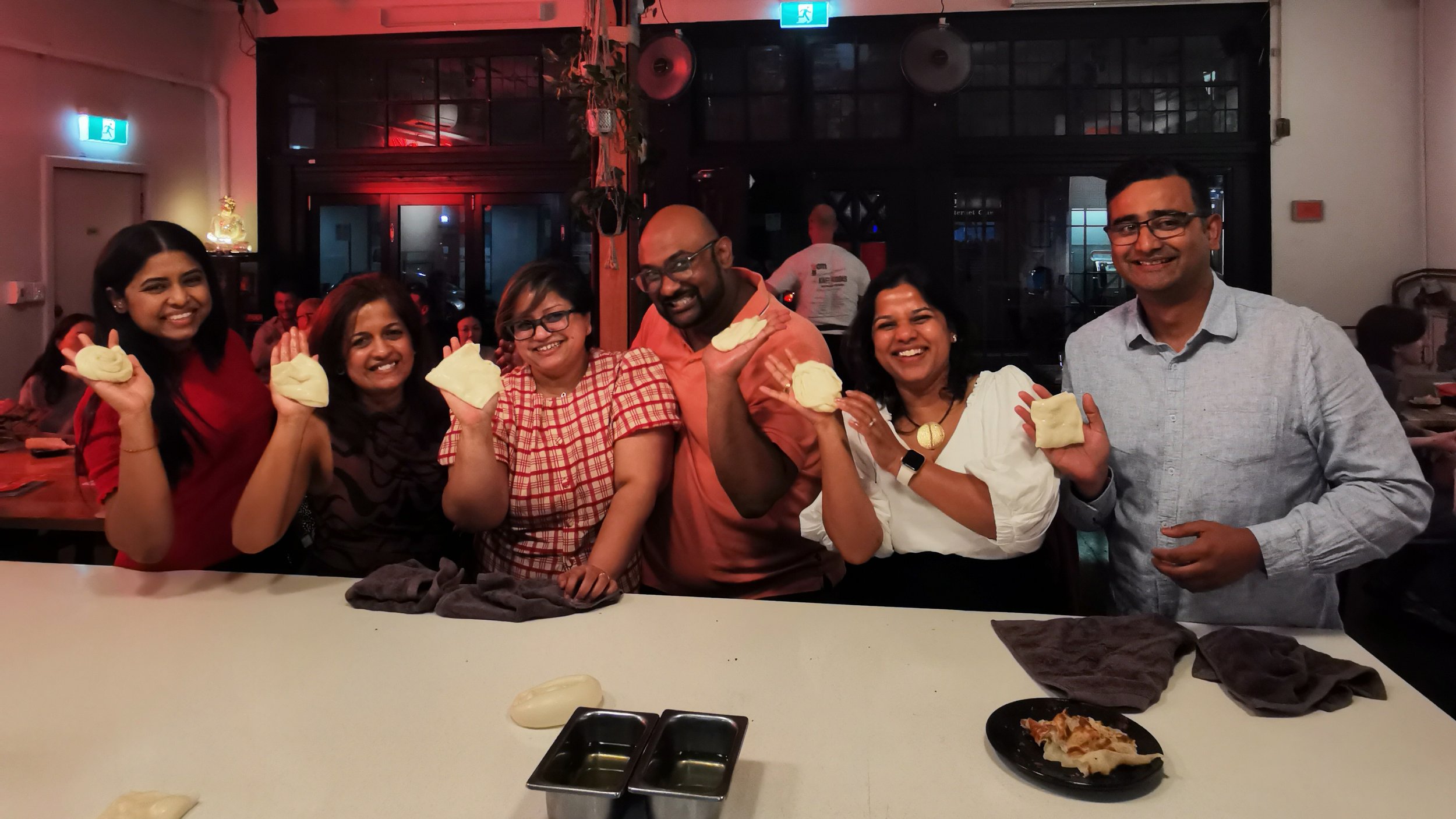 Guests posing with roti dough creation at Kafe Kooks Thursday class