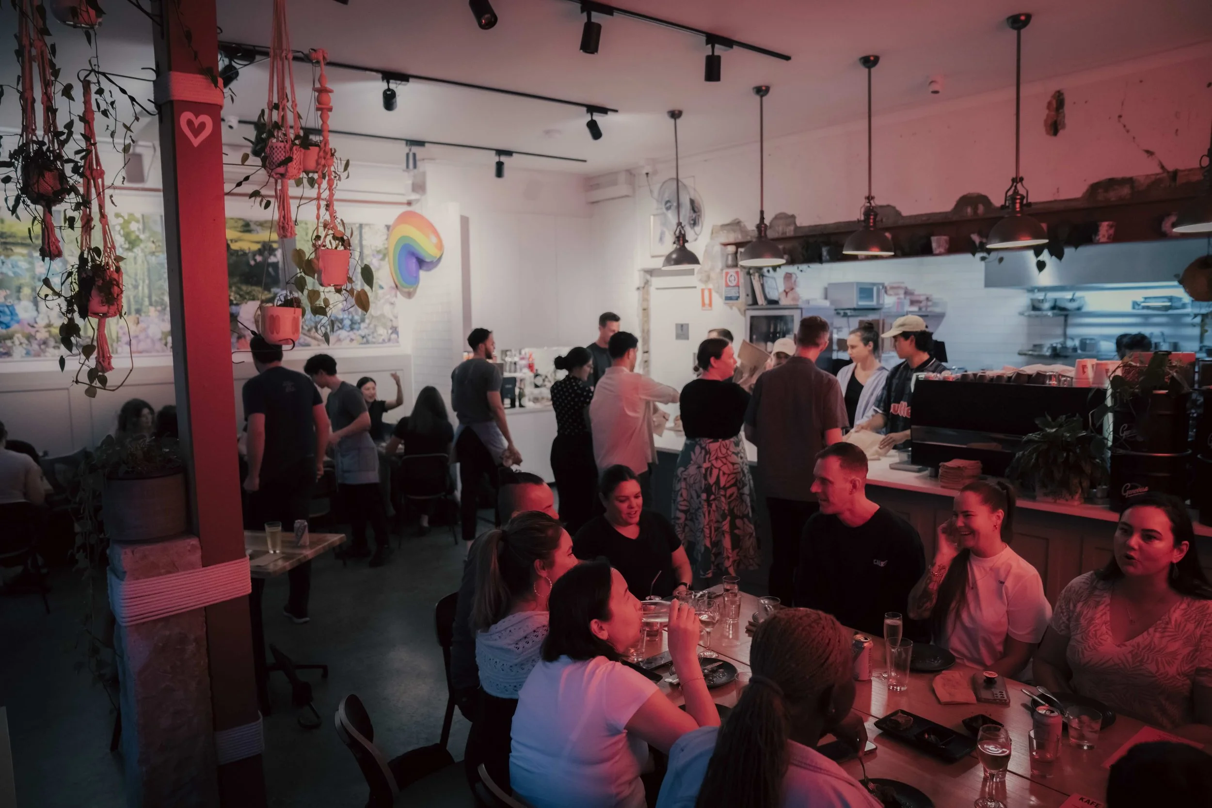 Large group enjoying dinner at a Kafe Kooks Roti Masterclass while other guests learn to make roti, a fun Christmas party and team celebration experience in Sydney