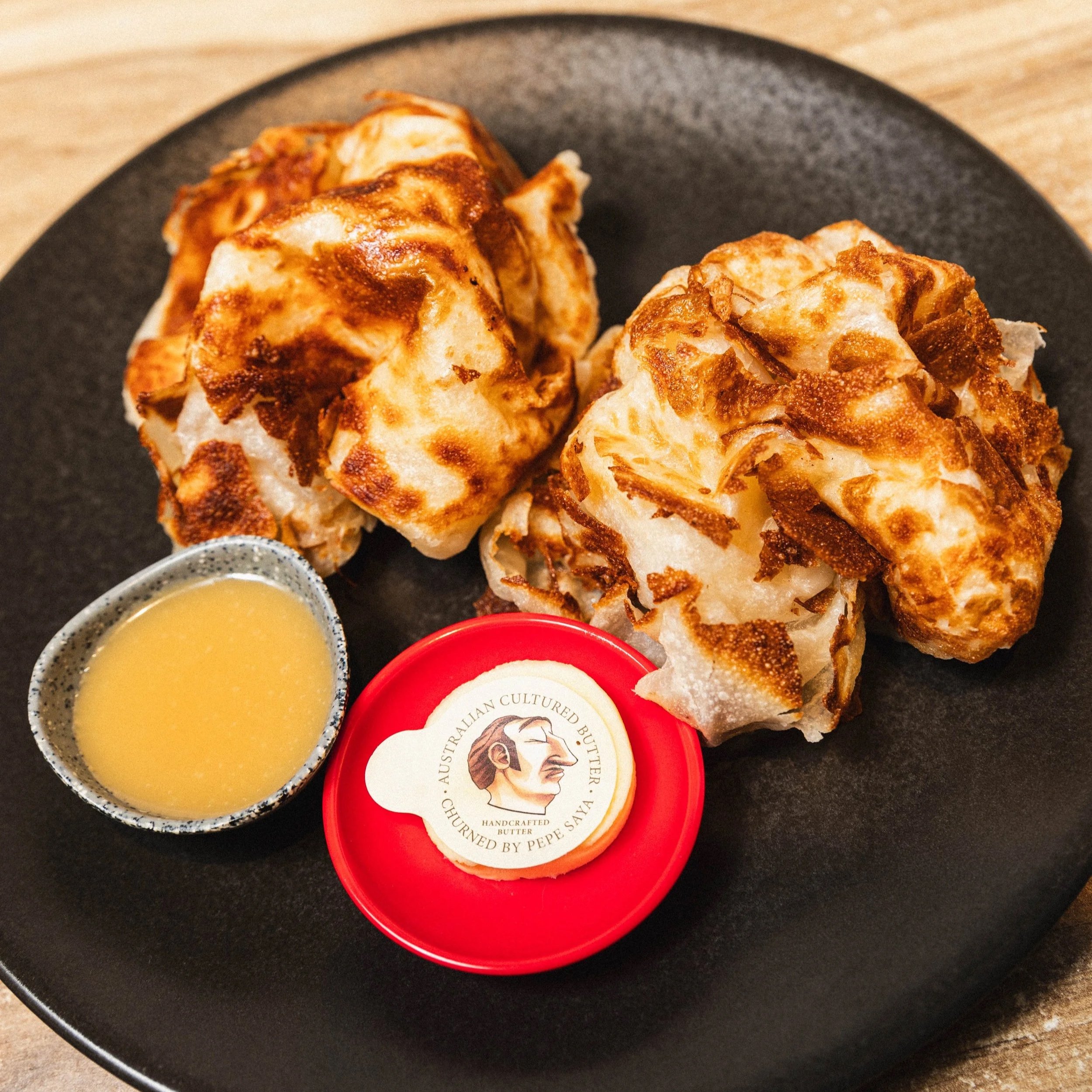 Freshly cooked roti paratha served with Pepe Saya Butter and house-made coconut jam