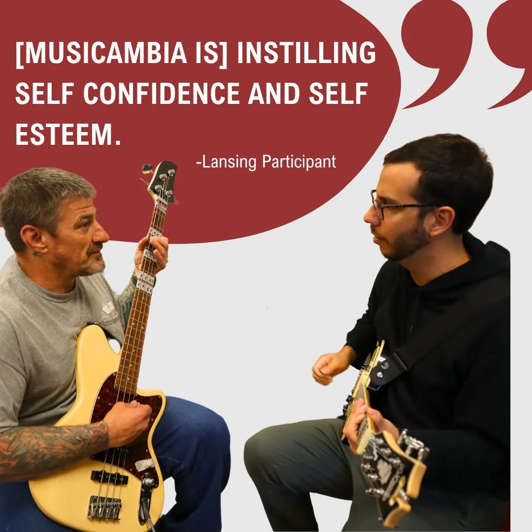 Two men sitting and playing guitars, engaging in a music therapy session. One man is older with tattoos and a beard, holding a bass guitar, while the younger man has glasses and is holding an electric guitar. The background features a quote about music therapy enhancing self-confidence and self-esteem.