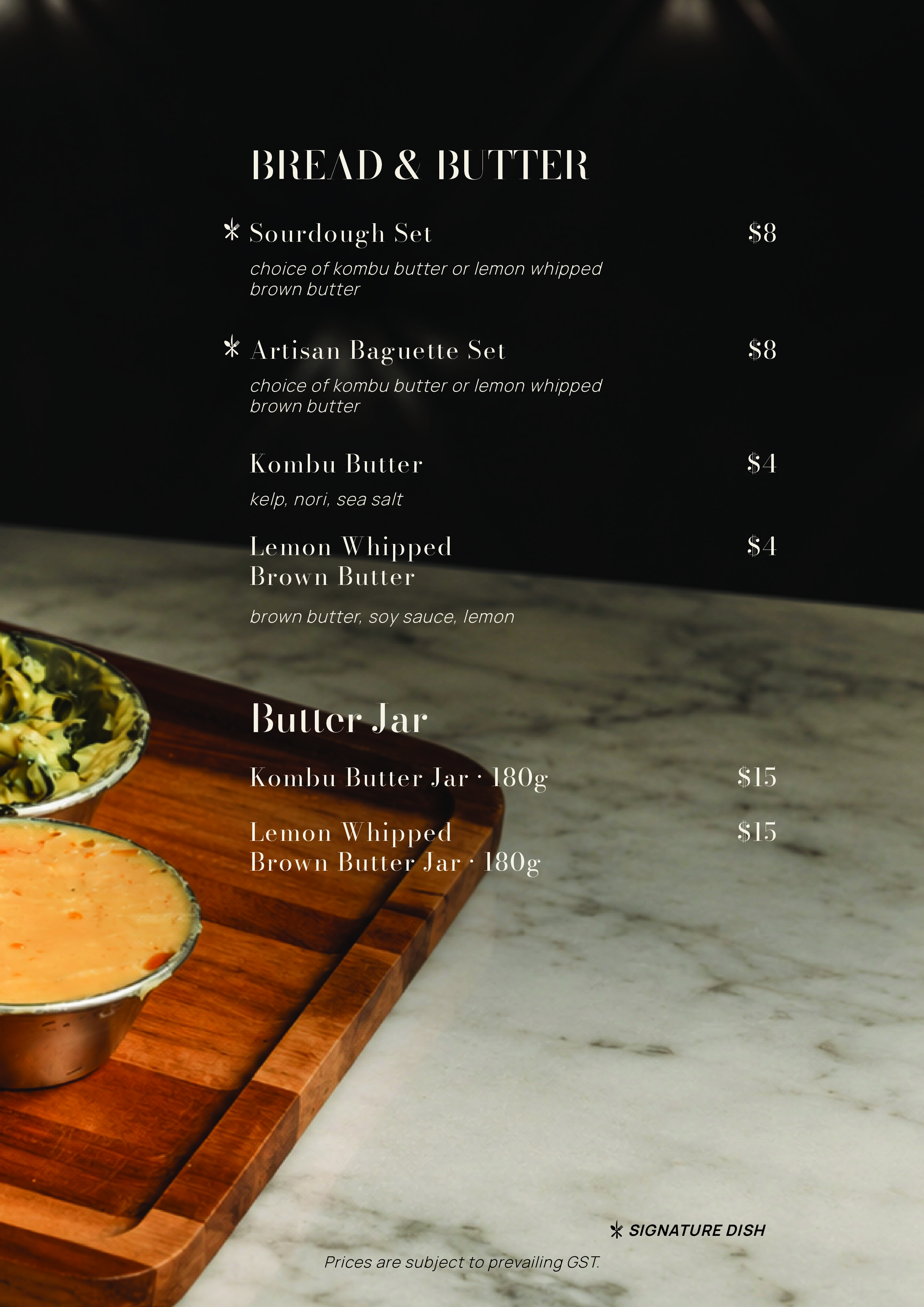 Menu listing various bread and butter sets and jars with prices on a black background, placed on a marble surface.