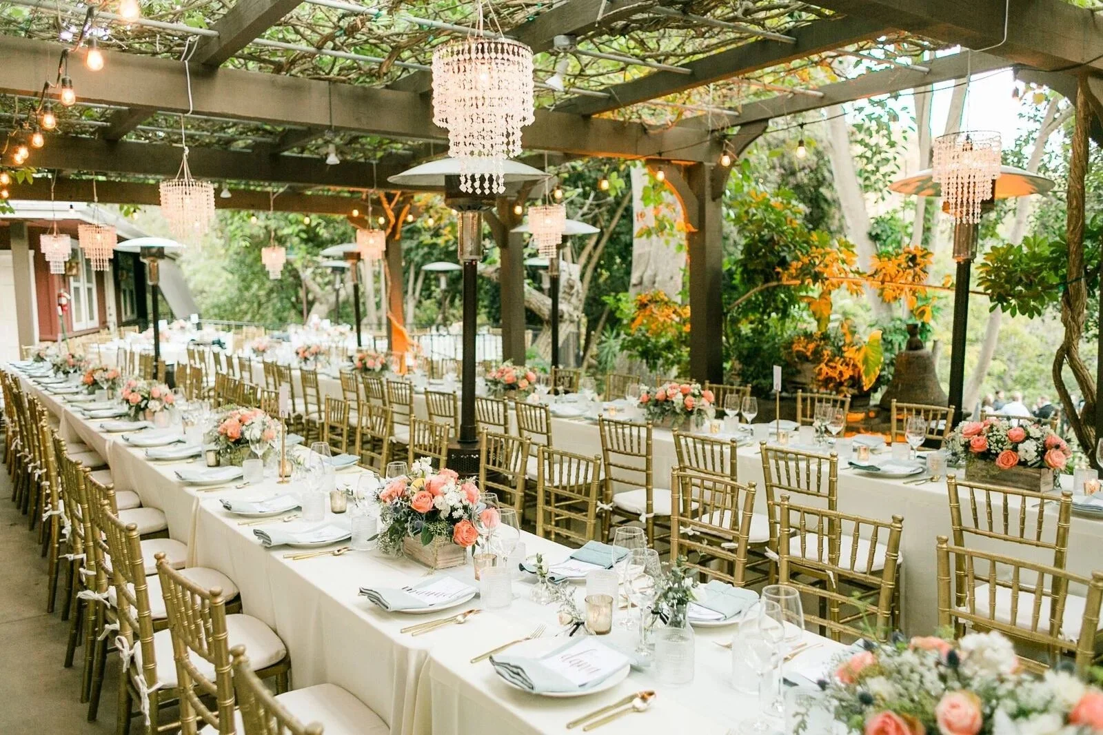 Wedding reception tables beneath a vine-covered pergola at Circle Bar B Guest Ranch in Goleta