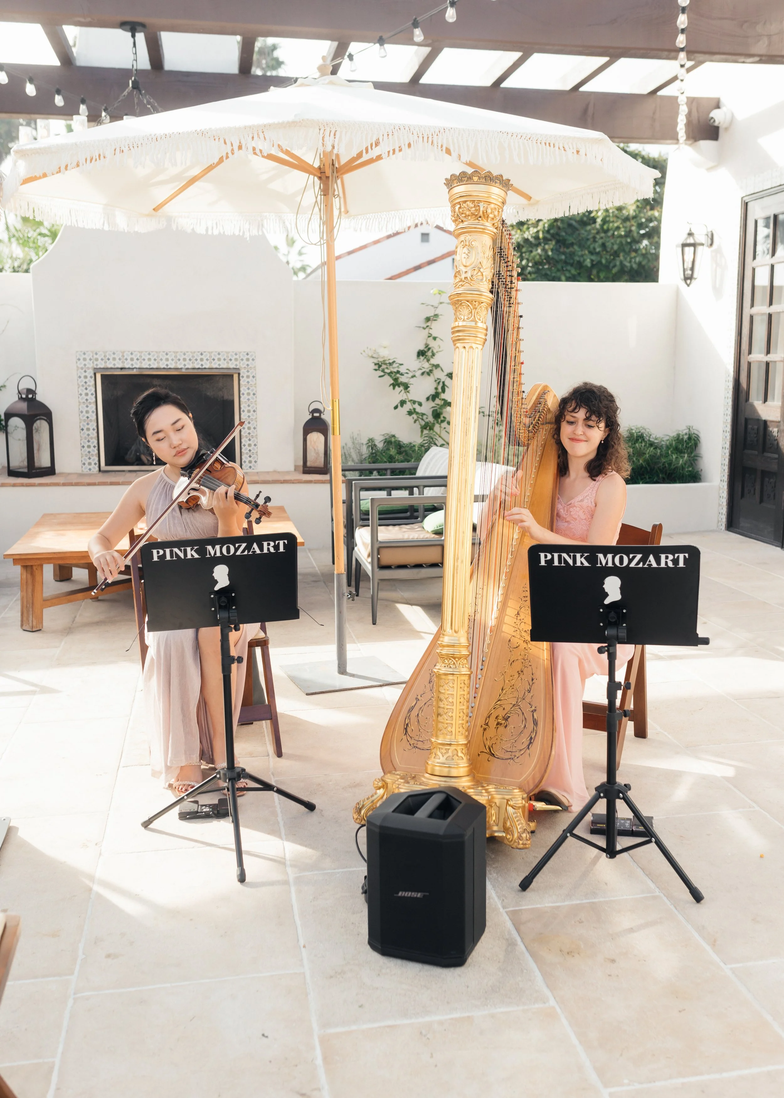 Pink Mozart harp and violin duo performing at Agápe 1928 in San Clemente
