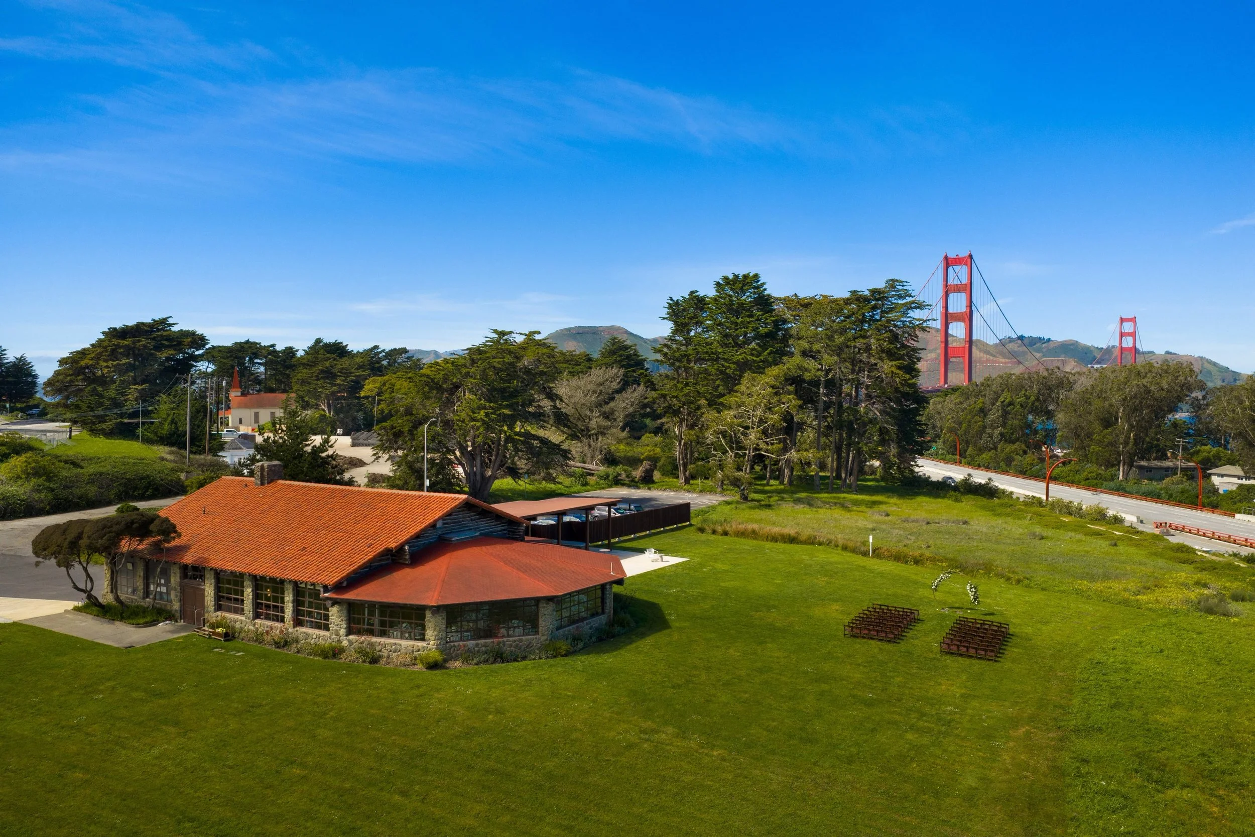 Log Cabin wedding venue and ceremony lawn in the Presidio, with the Golden Gate Bridge in the background