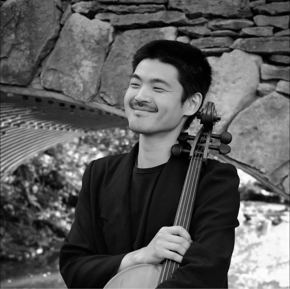 Black-and-white portrait of a Pink Mozart cellist with his cello