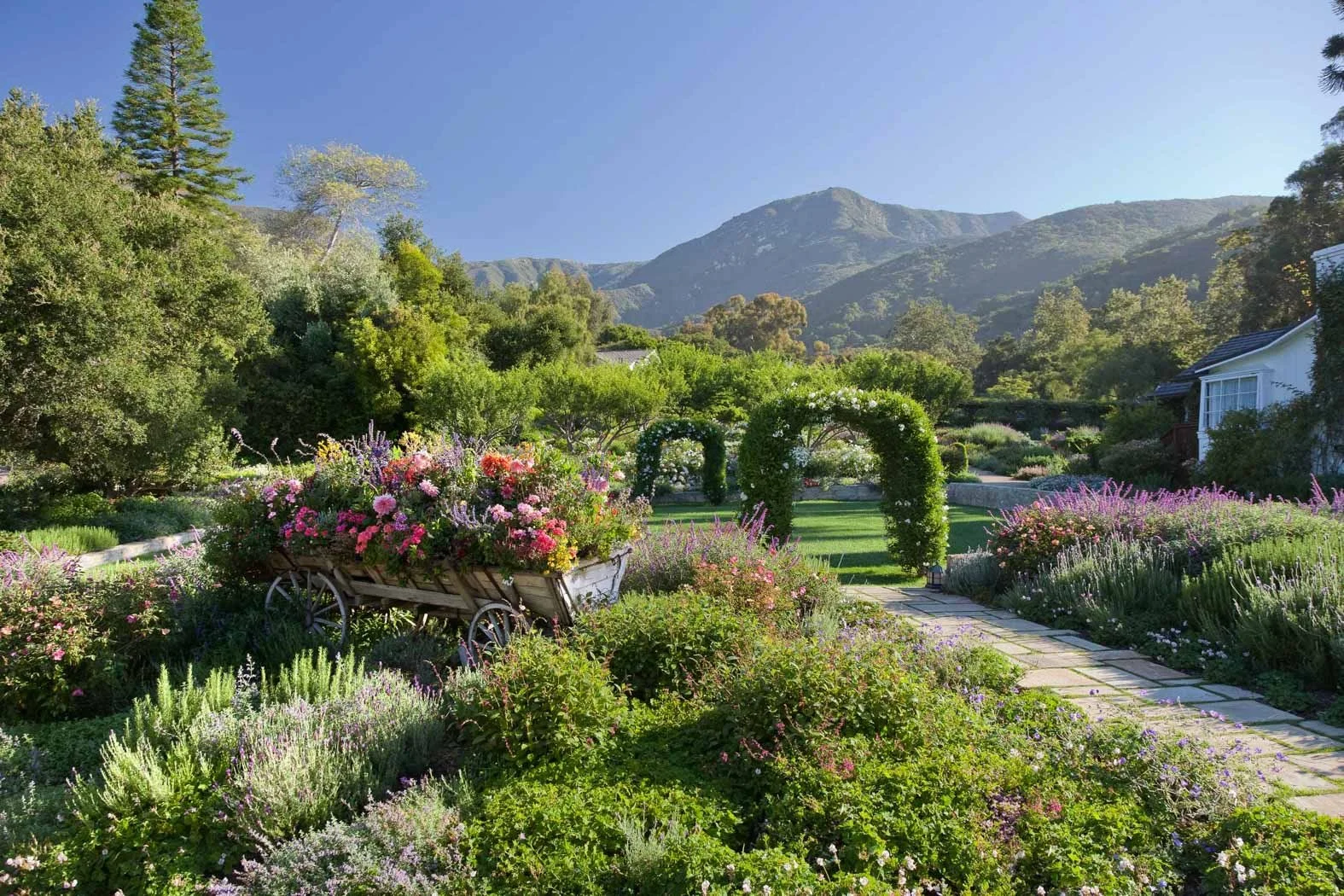 Garden arches and colorful flowers at San Ysidro Ranch in Montecito, with mountains in the background