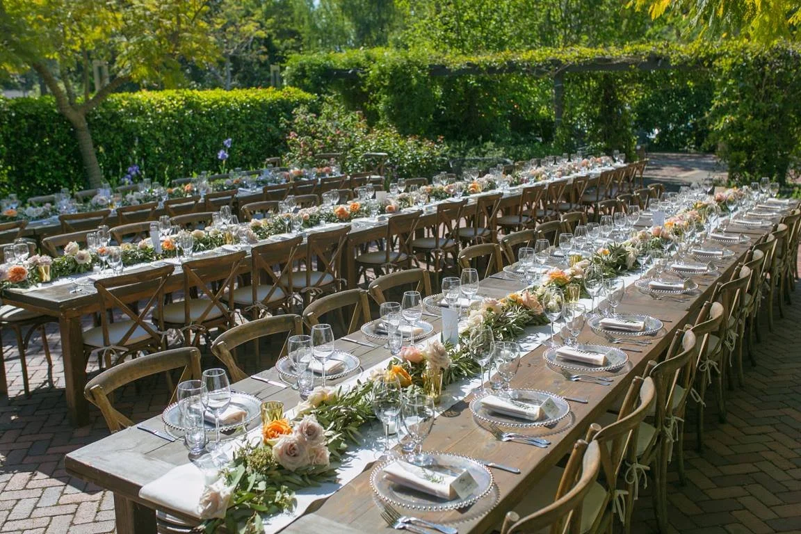 Garden wedding reception tables beneath greenery at Allied Arts Guild in Menlo Park