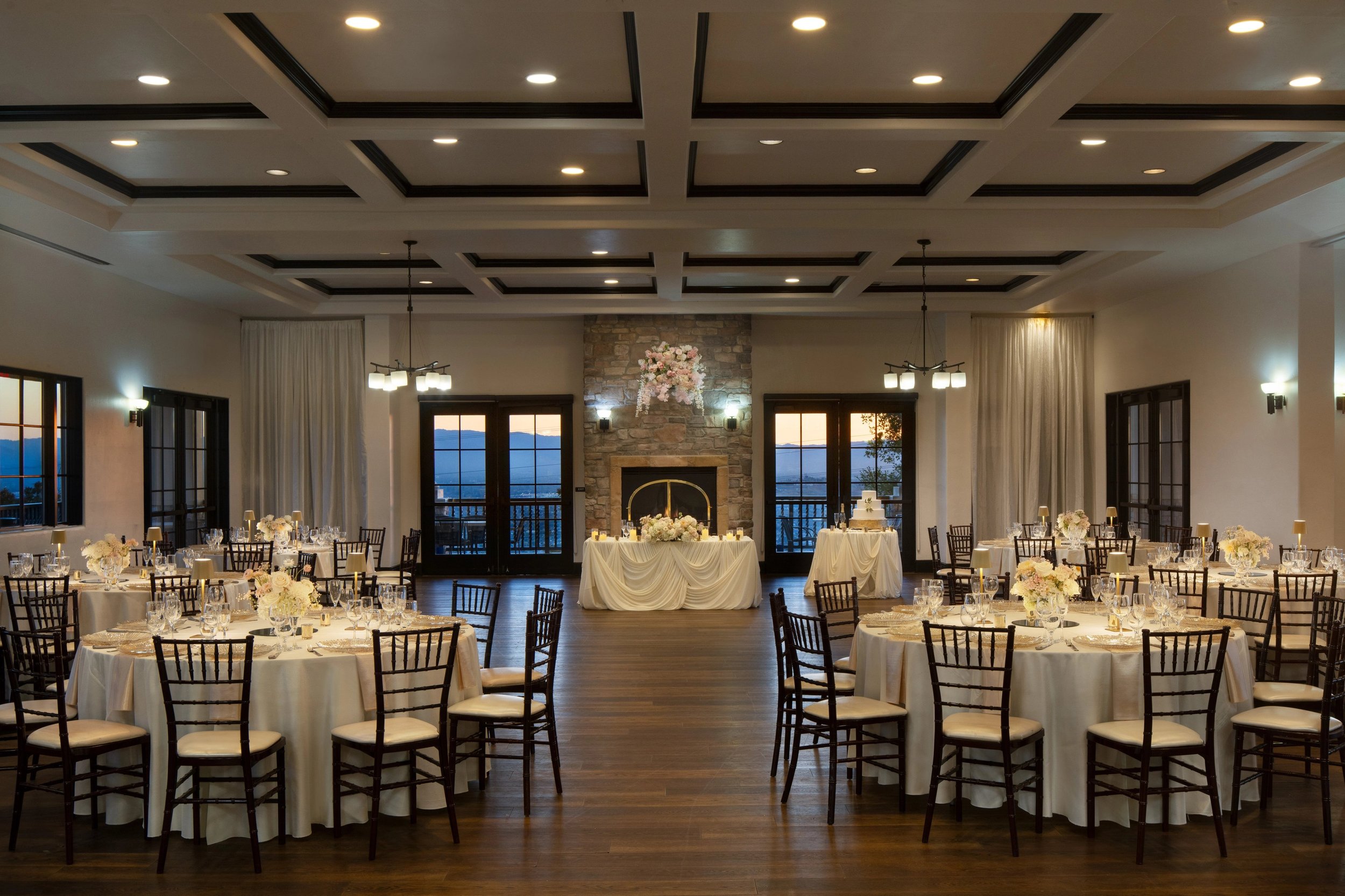 Wedding reception hall at The Ranch at Silver Creek in San Jose, with a stone fireplace and hillside views