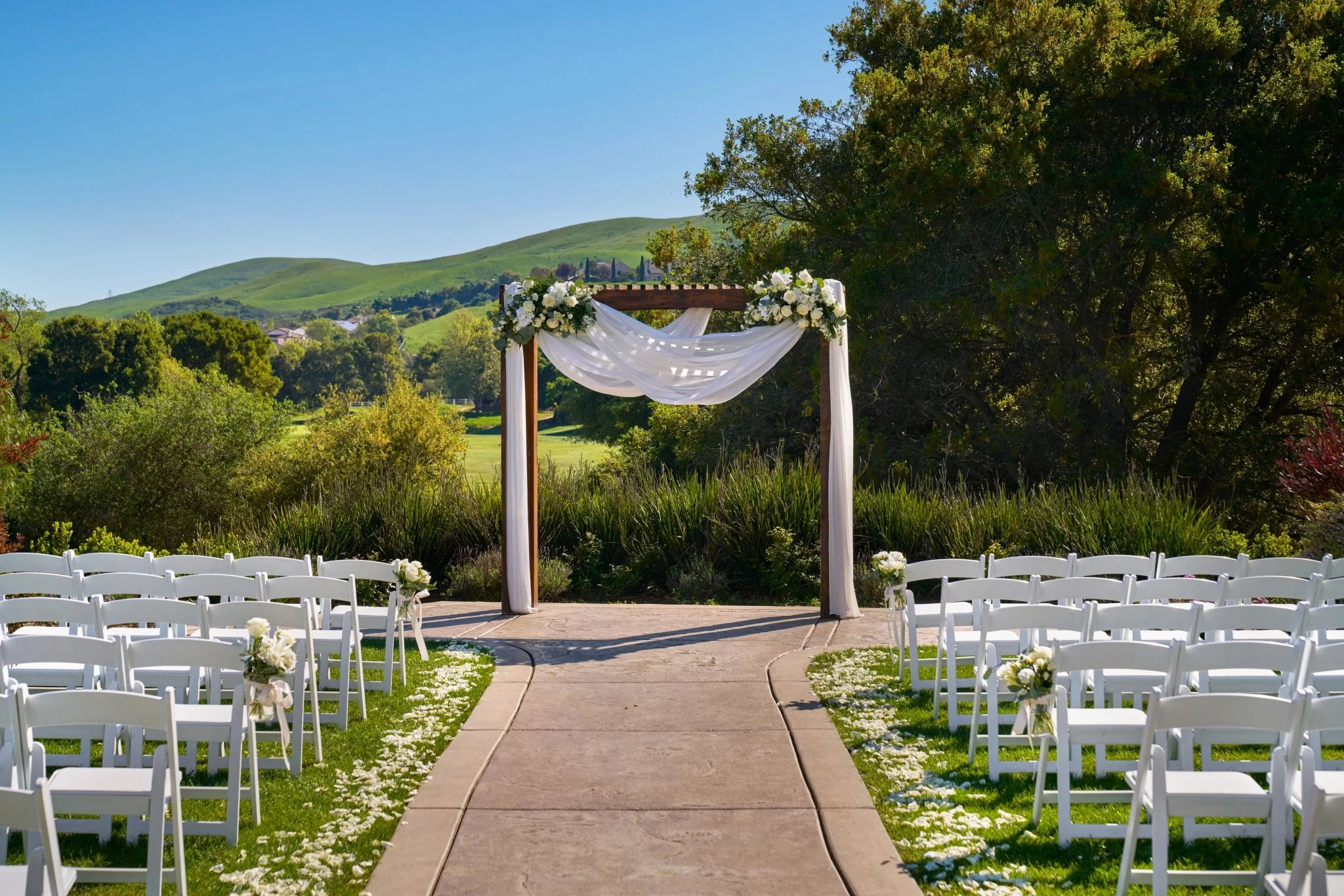 Outdoor wedding ceremony arbor at Hiddenbrooke Hills in Vallejo, overlooking green hills