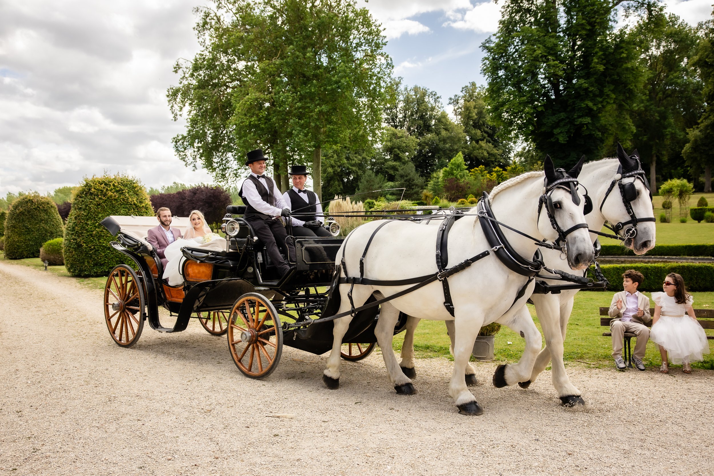 Arrivée des mariés en calèche tirée par deux chevaux blancs au Château d’Aveny dans le Vexin, mariage chic et haut de gamme près de Paris – photo Stéphane Bourgeon Photography