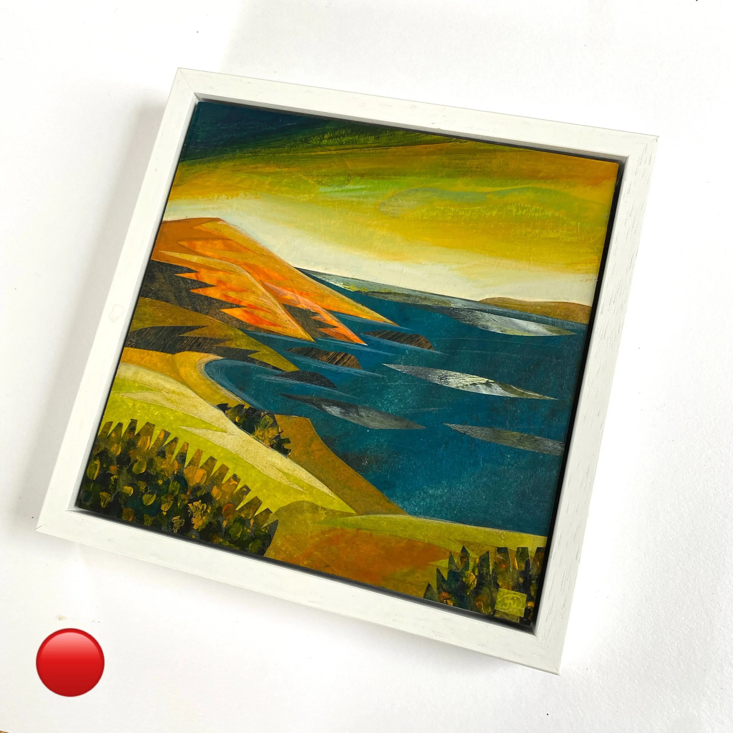 Framed landscape painting of rolling hills, cliffs, a river, and a sunset sky with yellow, orange, and green hues.