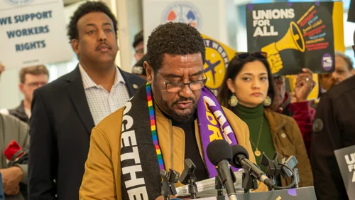 Dawit Kassa speaks at a press conference alongside State Representatives Samakab Hussein and María Isa Pérez-Vega