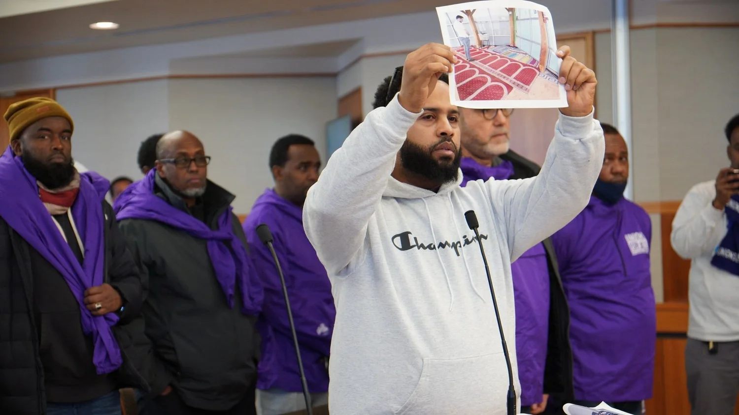 Driver holding up a photo of a prayer room at a MAC meeting