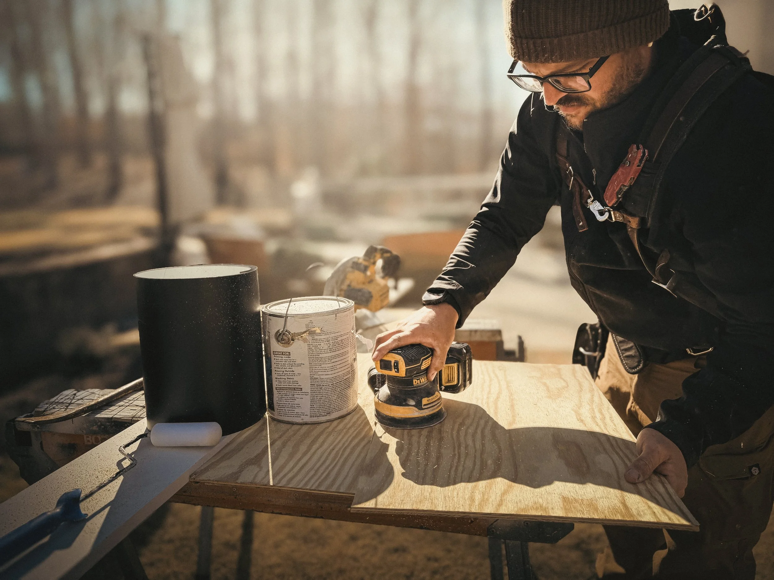 Close-up of an Athens, GA builder sanding plywood edges before priming to ensure a smooth, professional paint grade finish.