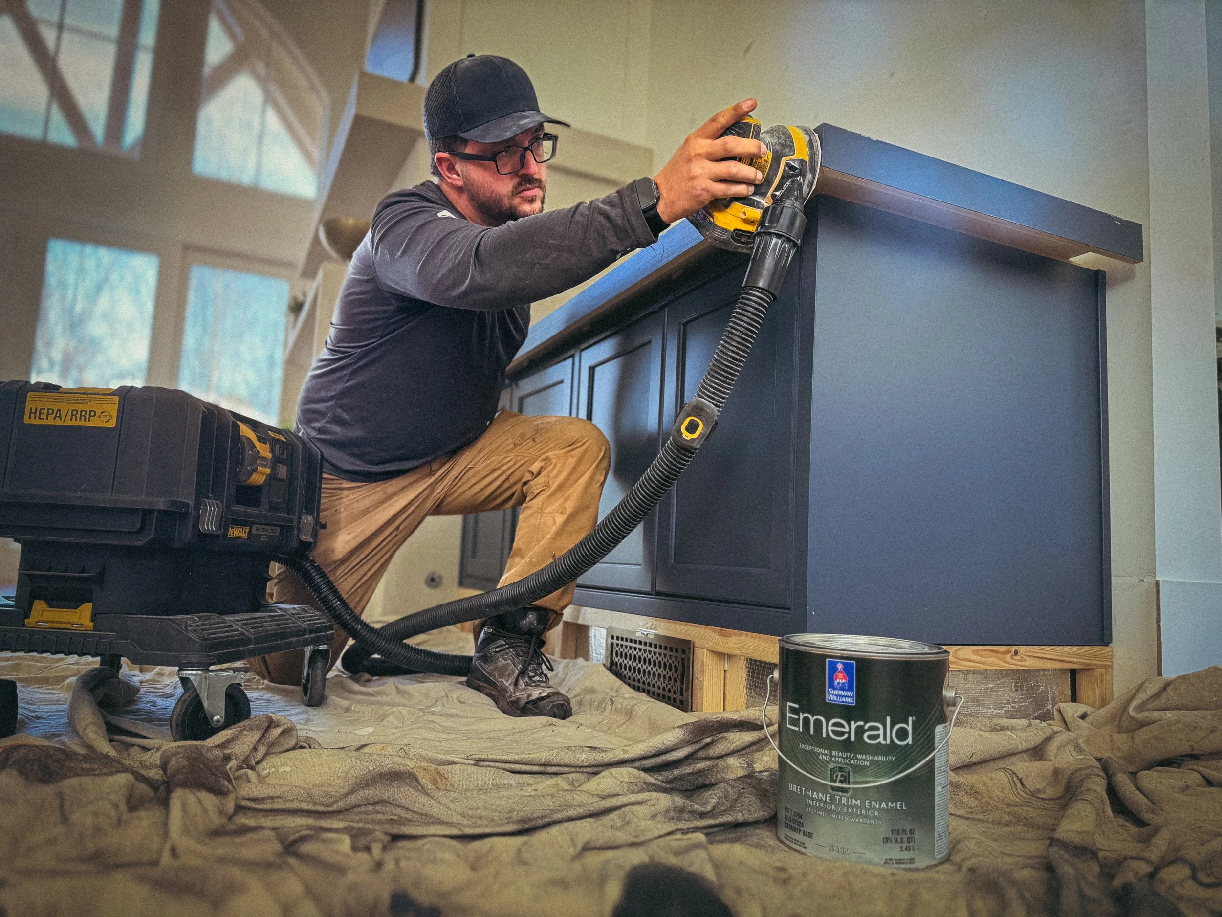 Athens, Ga based Handyman that is sanding between coats of paint on a cabinet countertop using a dewalt hepa vacuum with orbital sander attached.