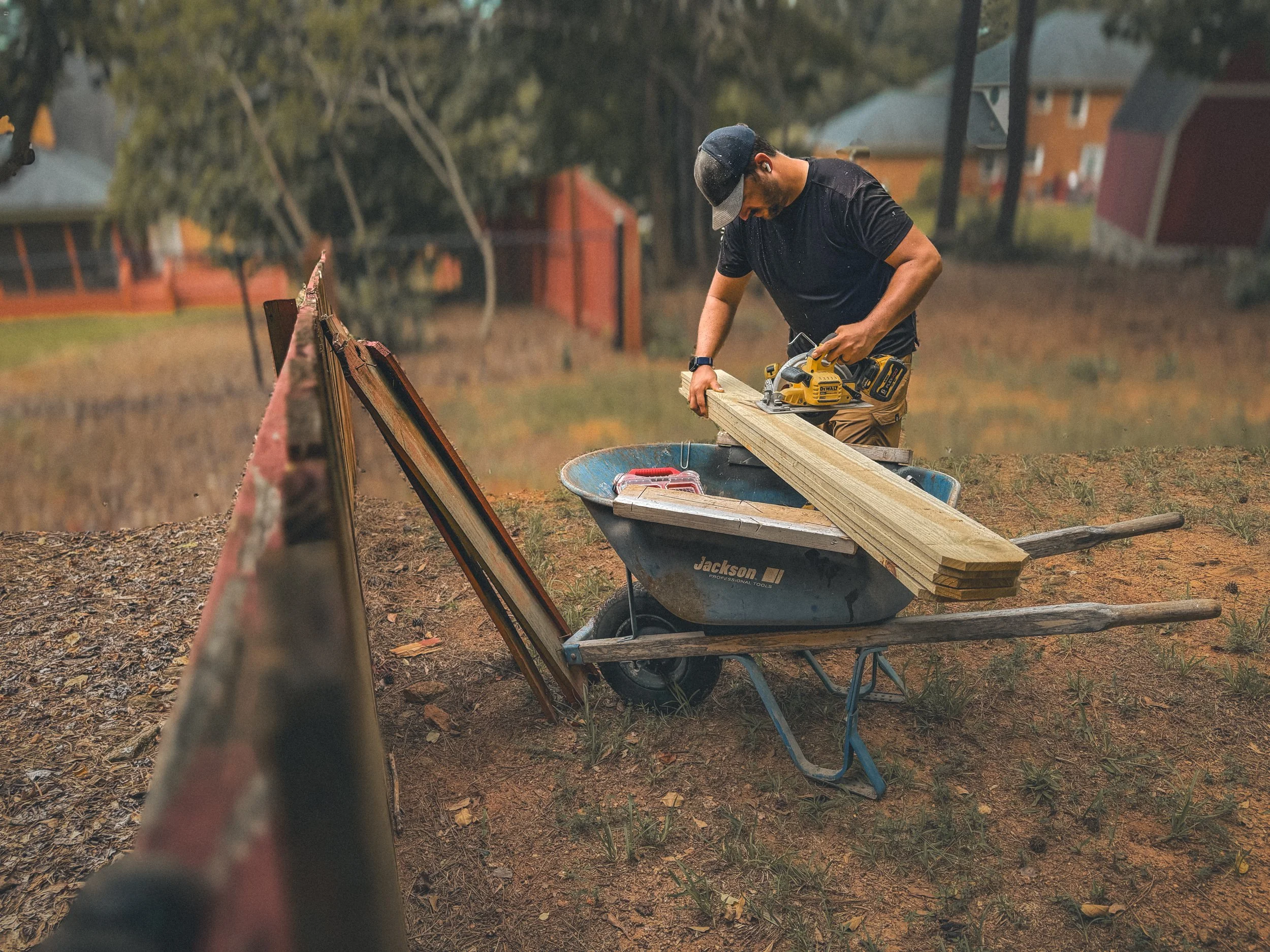 Carpenter cutting a stack of fence pickets for a fence repair in Watkinsville, GA