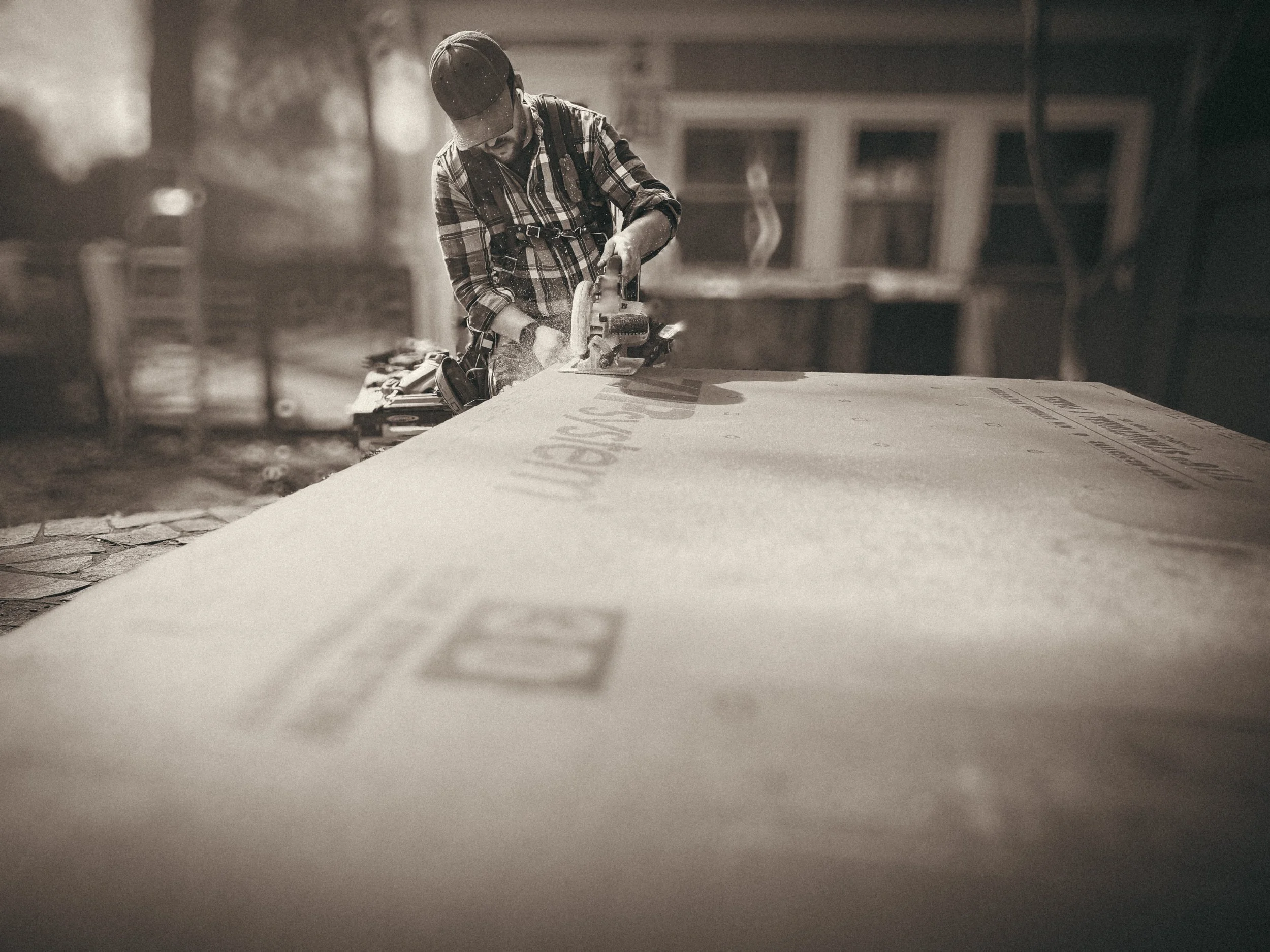 Professional carpenter in Athens, GA, cutting Zip System sheathing for a residential construction project.