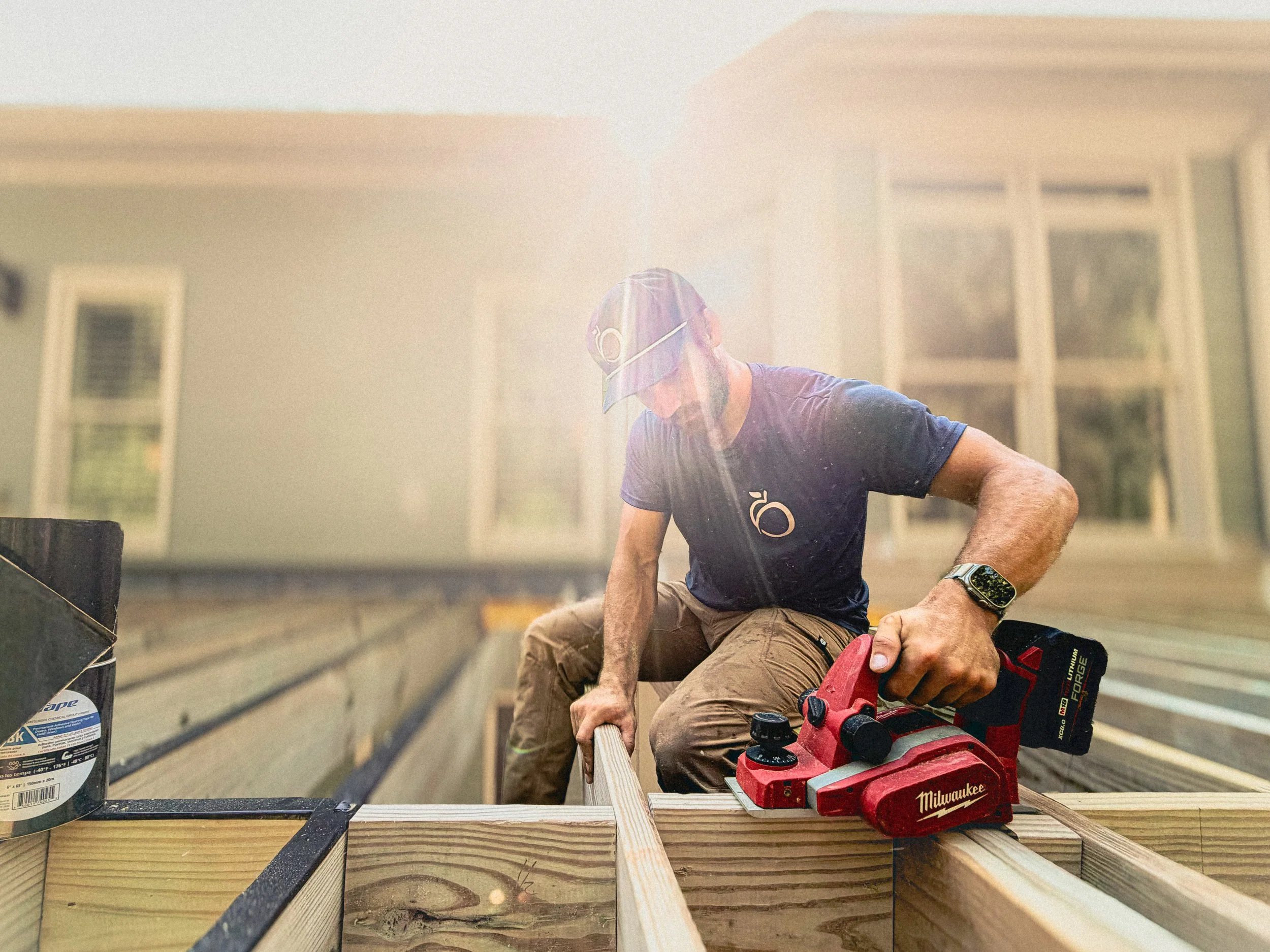Athens, GA based carpenter using a Milwaukee power plane to level joist before adding joist tape
