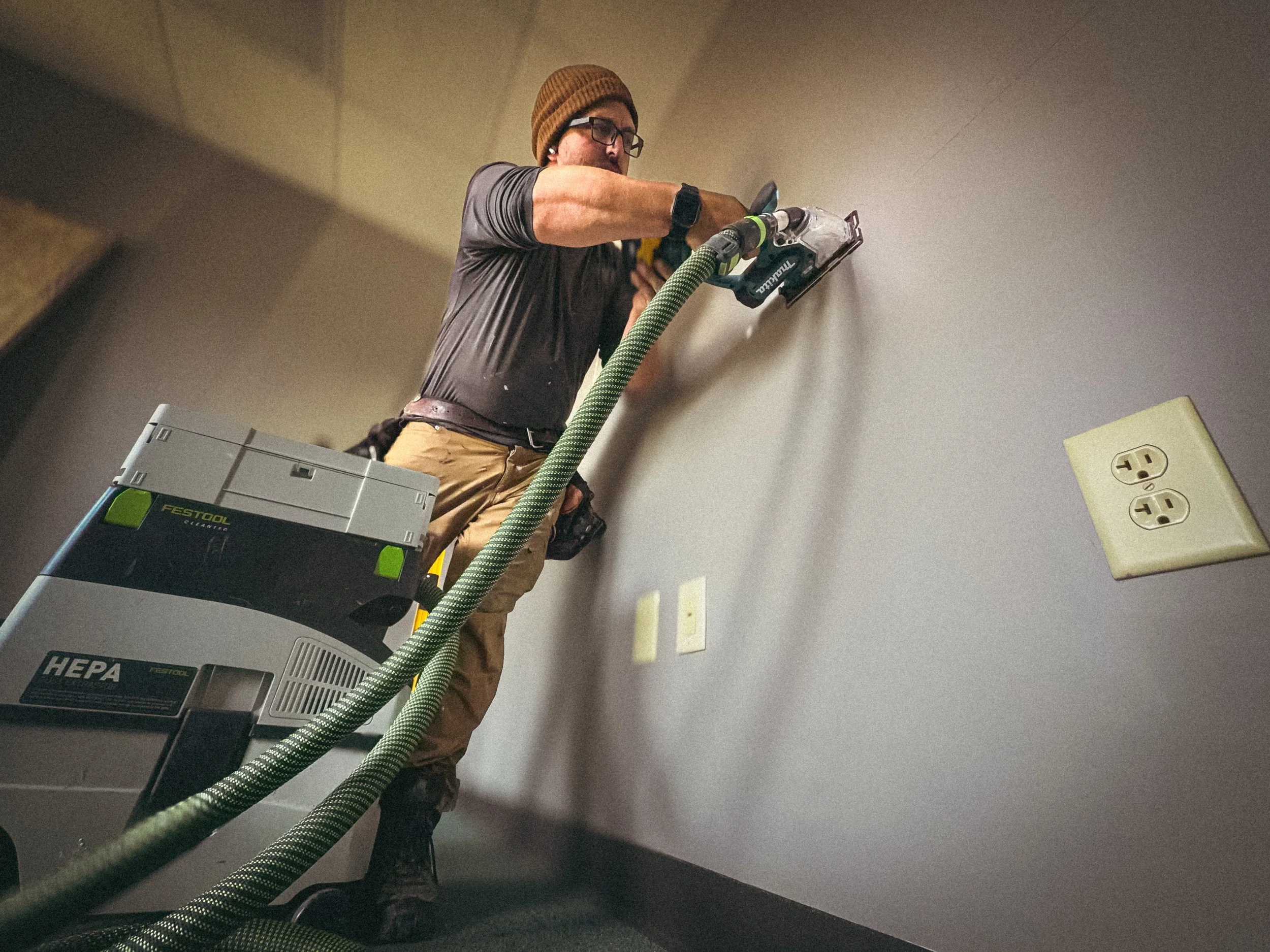 Handyman in Athens, GA removing drywall in a commercial building with a Makita drywall saw for a service window