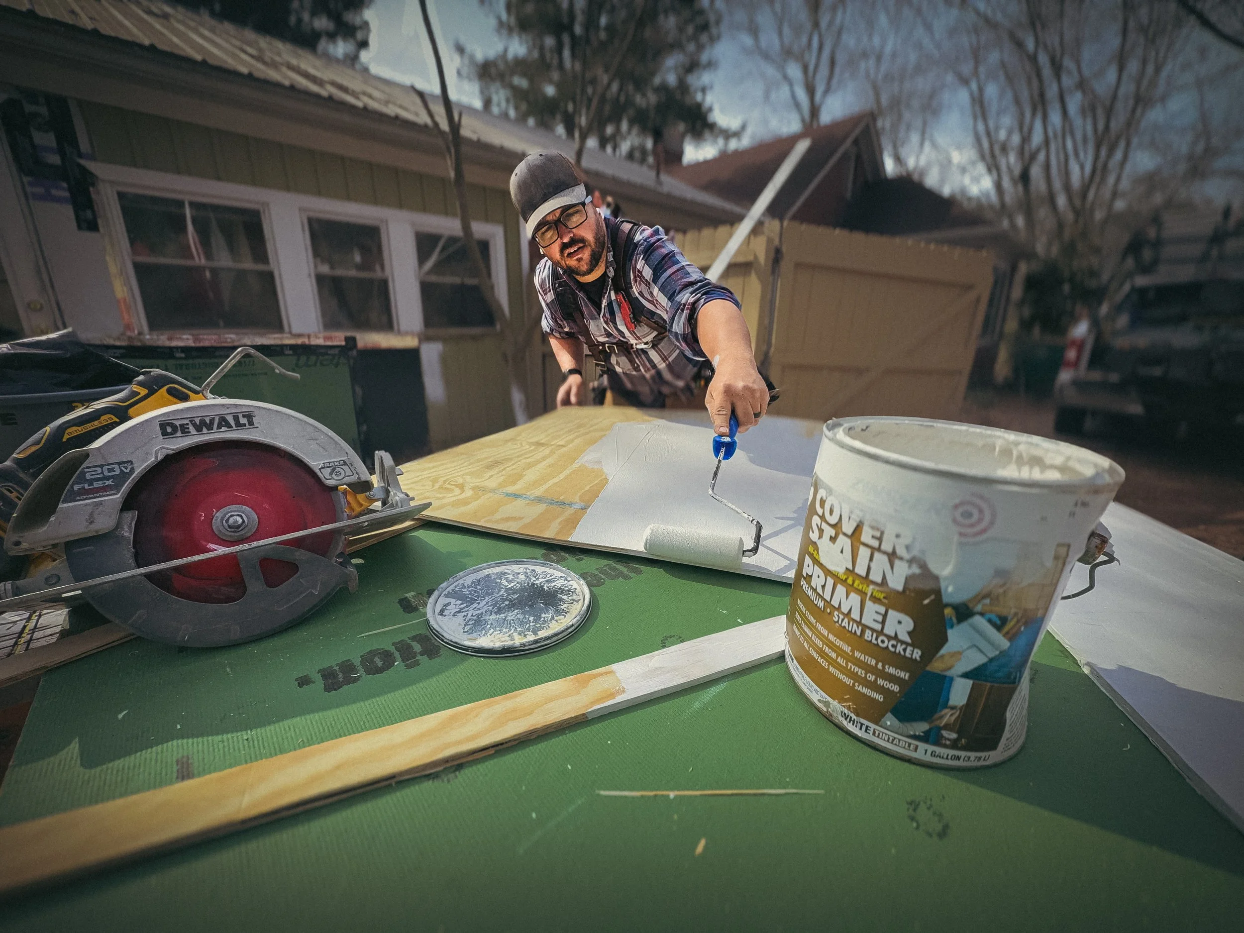 Contractor in Athens, GA, sealing BCX plywood with Zinsser oil-based primer next to a DeWalt circular saw.