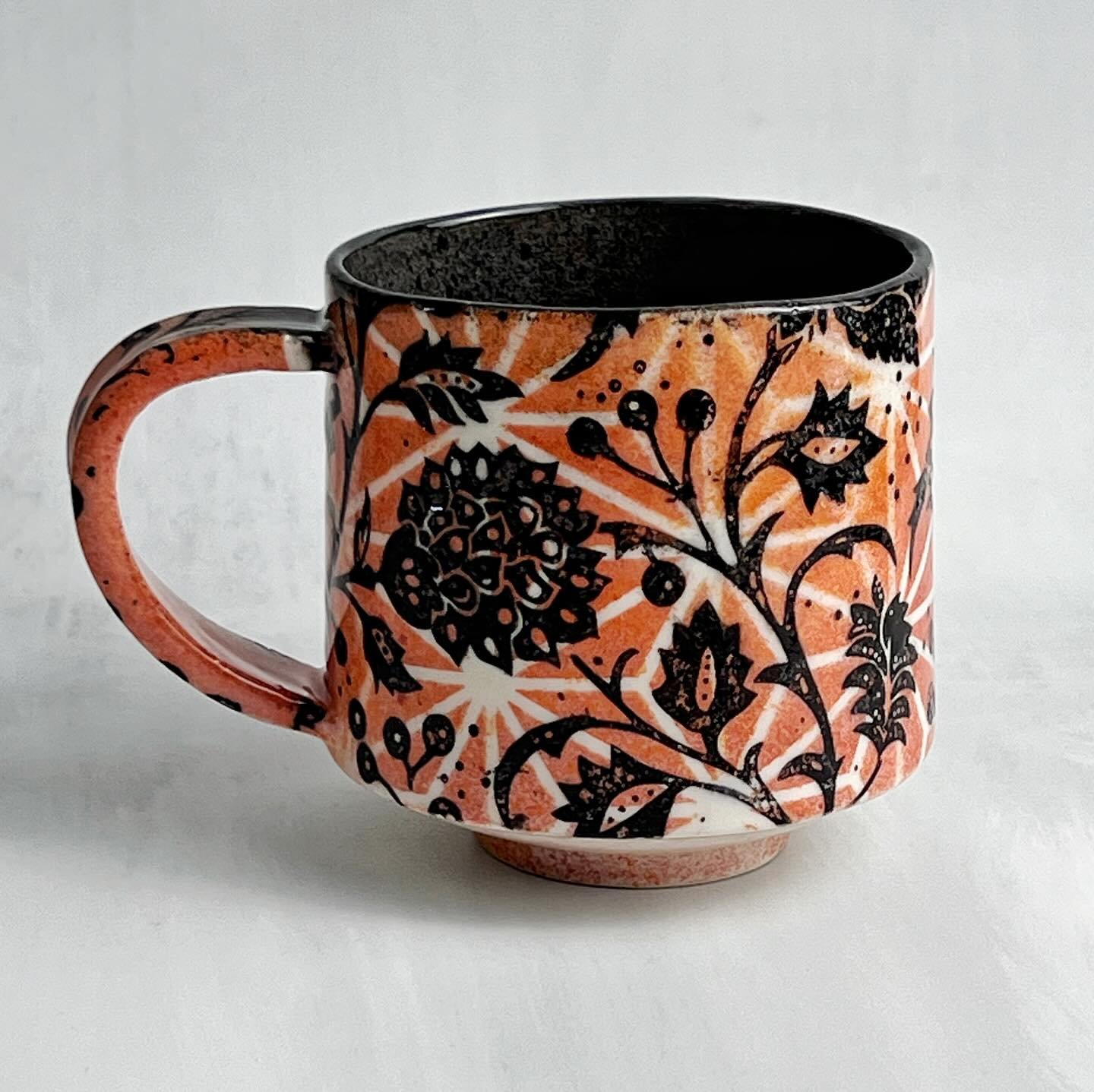 Slip cast mug, decorated with the Kalamkari Underglaze Transfer over a sprayed red underglaze using the Nautical Stars stencil as a mask.