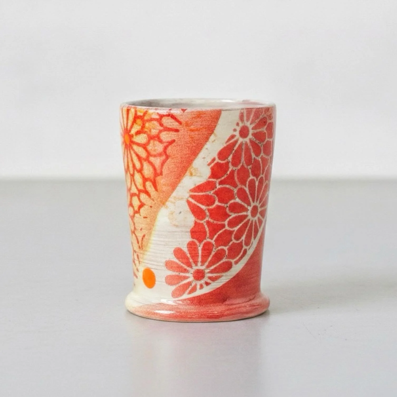 I wish I could tell you how I did the surface decoration on this cup, but I can&rsquo;t remember since I made it back in 2021 and it is long gone now. I can tell you it involved the red Daisy Lace underglaze transfer, the Daisy Lace stencil, Amaco&rs