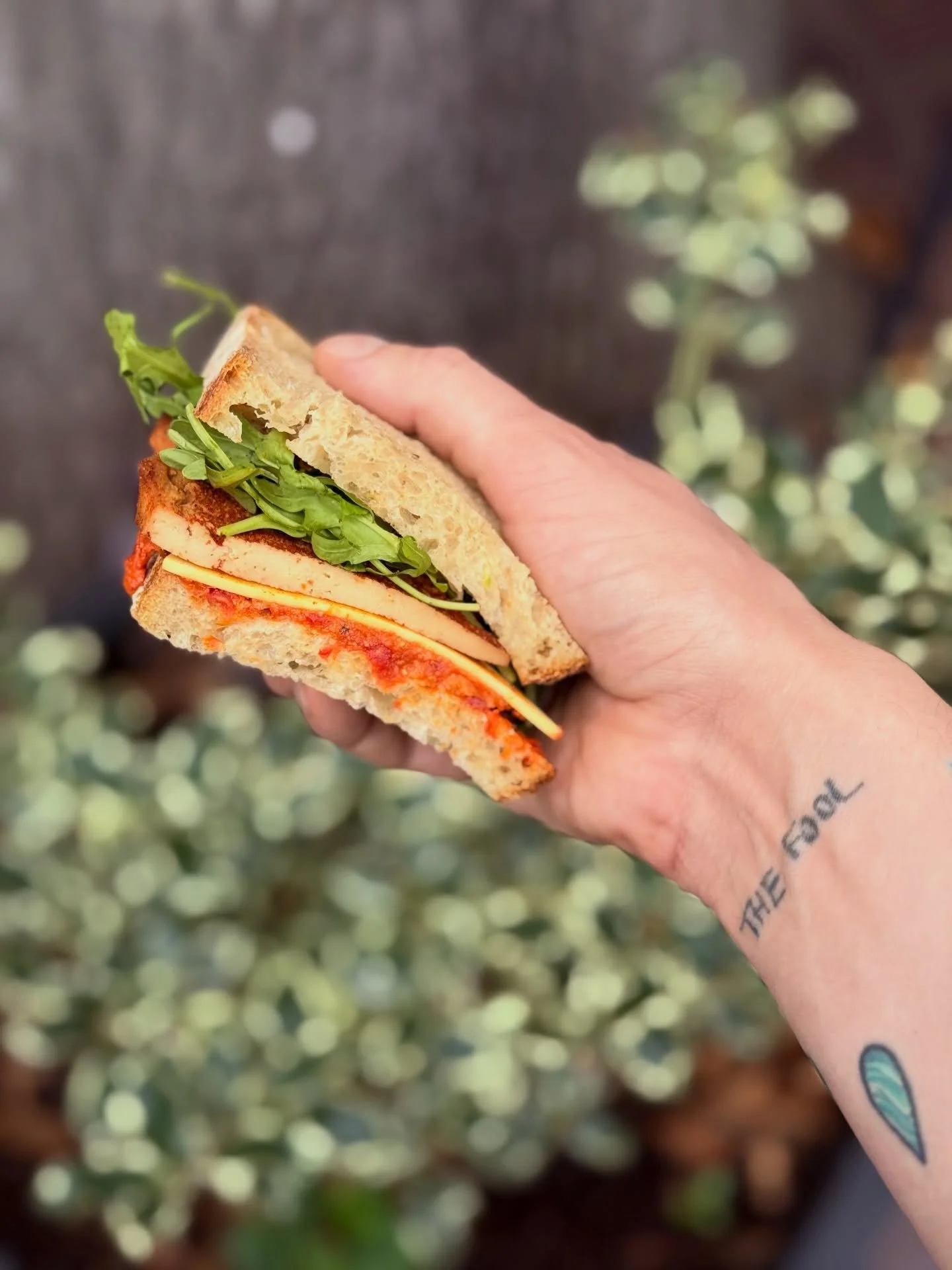 She&rsquo;s so back ✨ Get in on a lil Sun-dried Tomato &amp; Tofu Sandwich action today with our &ldquo;honey&rdquo; glazed tofu 🐝, sundried tomato pesto ☀️🍅 , arugula 🥬, &ldquo;smoked gouda,&rdquo; 🧀 and an herby mayo 🤍