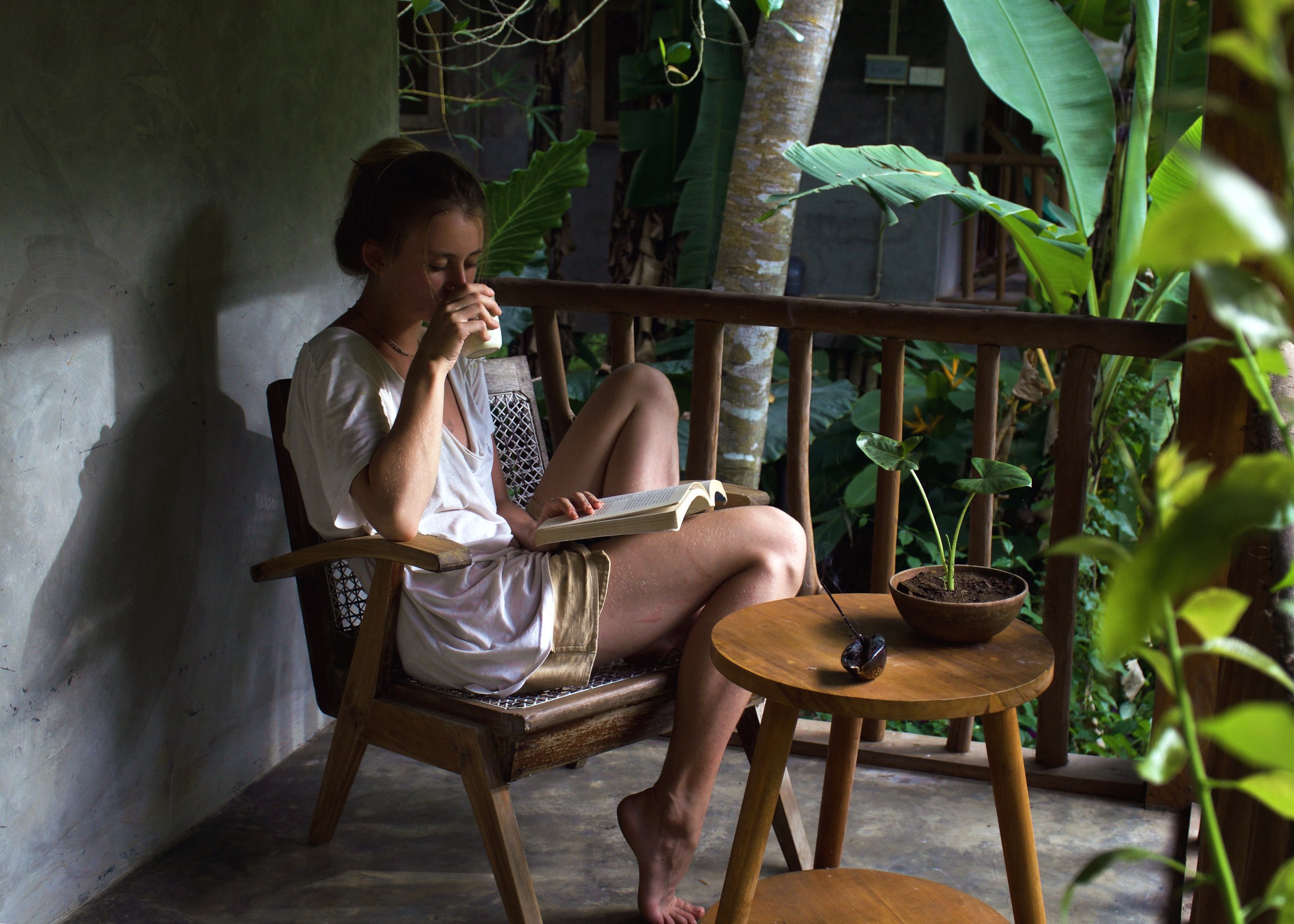 Guest sitting on the Island Cottage balcony overlooking de garden, minutes from the beach, in sri lanka