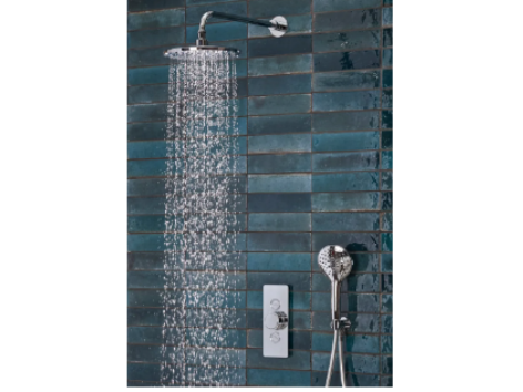 Rain shower head with water running in a bathroom with dark blue tiled wall.