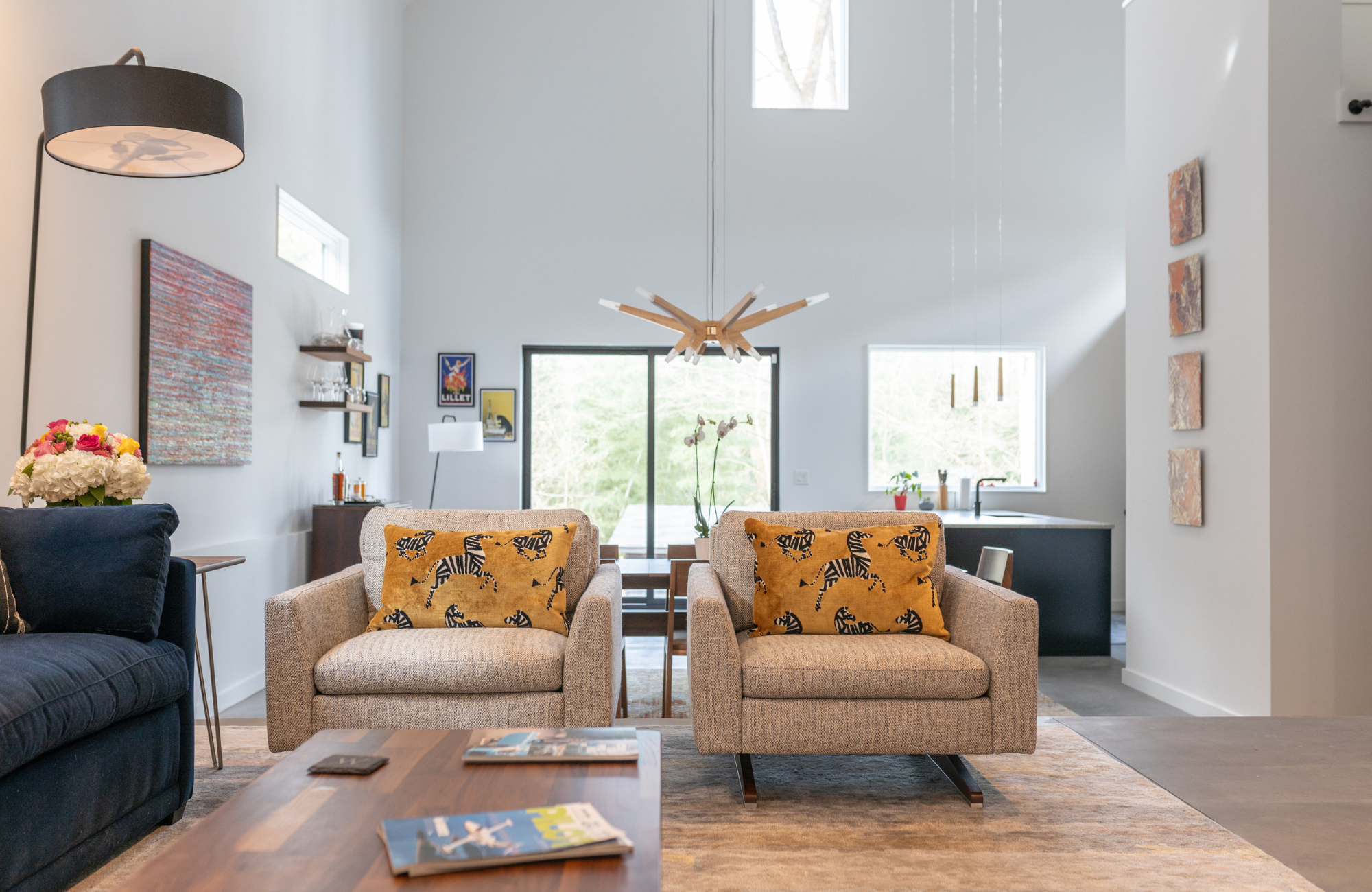 susan-hill-design-group-huntersville-nc-defined-areas-in-open-floor-plan-living-room-two-upholstered-chairs-by-blue-sofa-high-ceiling-family-life.png
