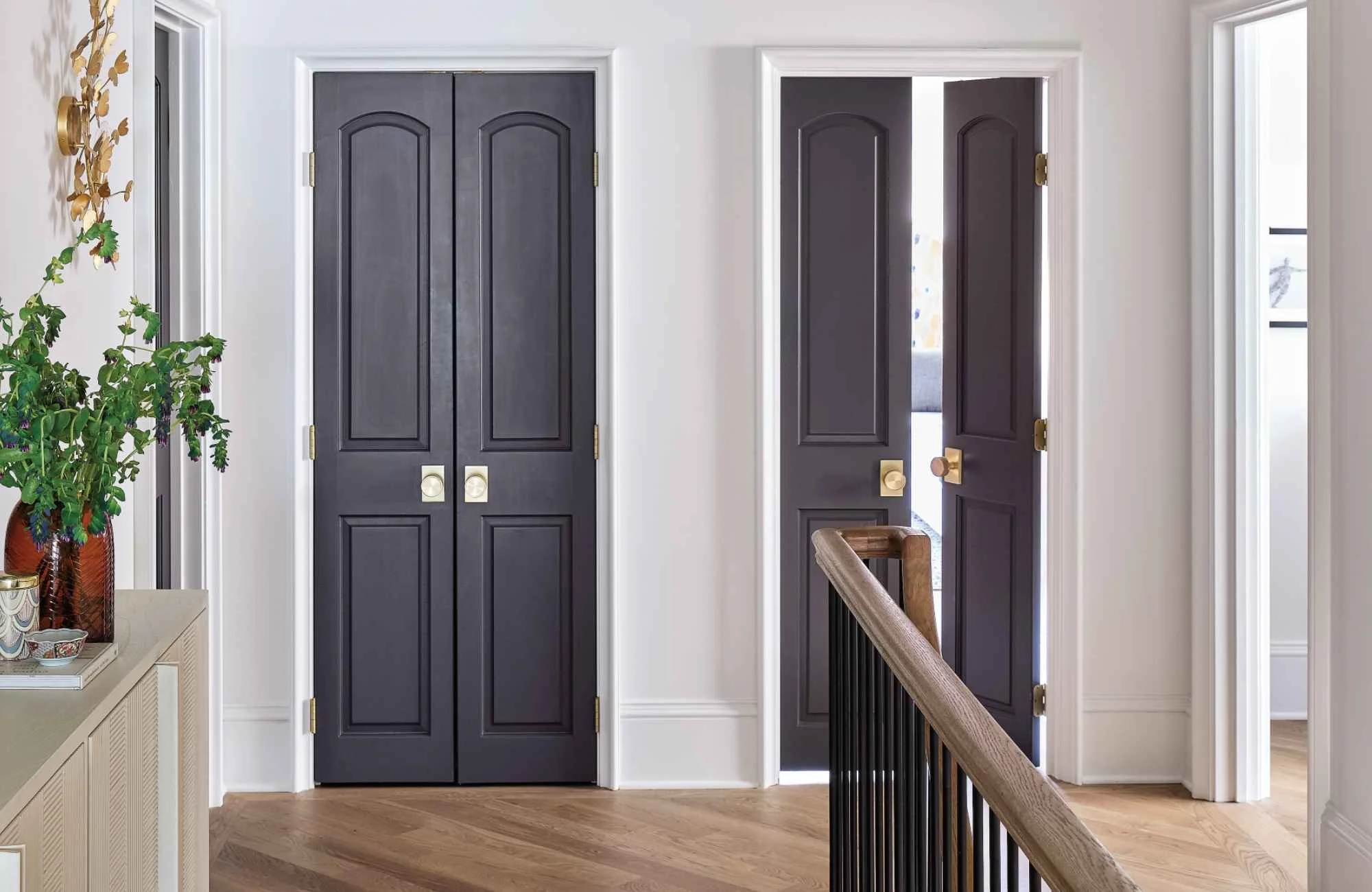 full-service-interior-design-charlotte-nc-interior-door-hardware-styles-two-dark-doors-with-brass-knobs-at-top-of-stairs-turnkey-new-build-custom-home-.jpg