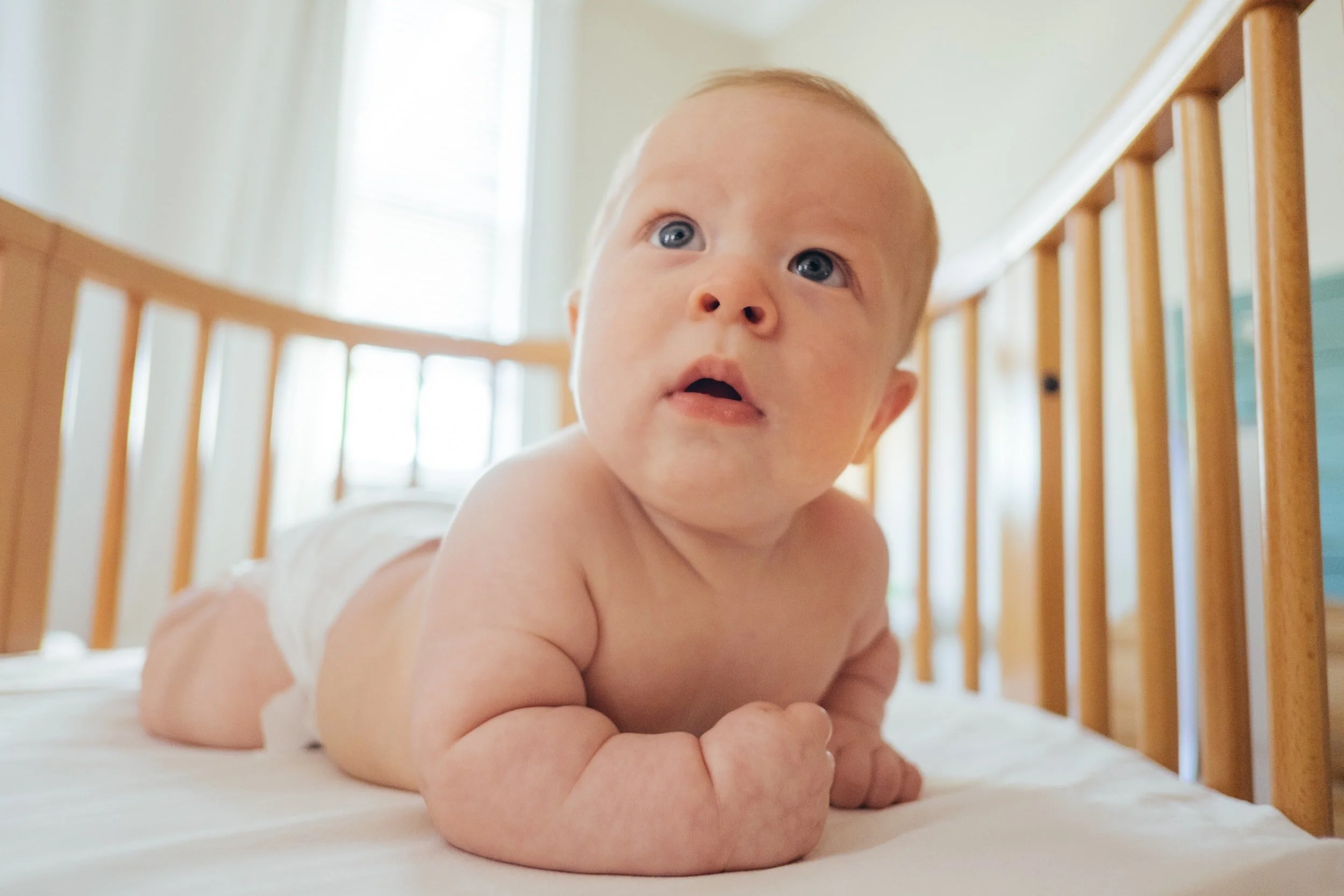 Baby on tummy time in crib
