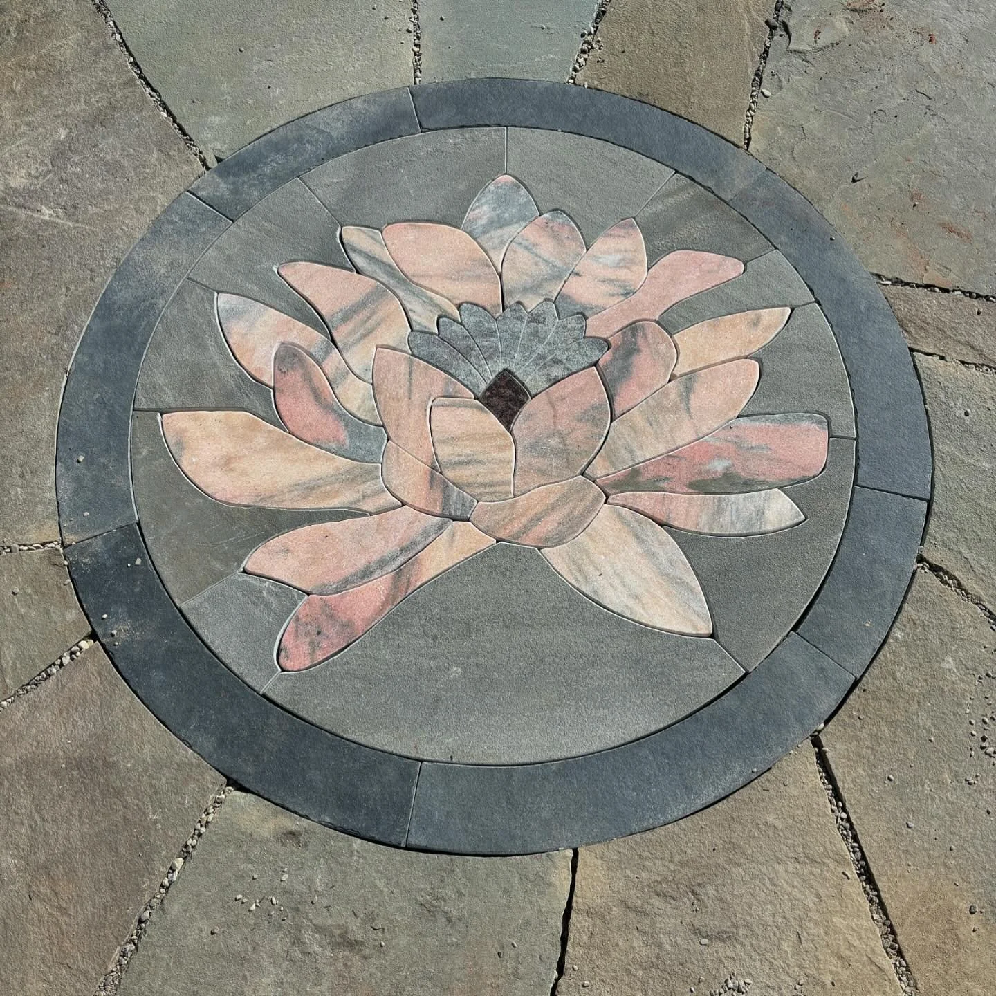 Lotus mosaic installation in a patio we built. Flower is Etowah marble from Georgia. Mosaic is laid dry over gravel. #hammerheadstoneworks #mosaic