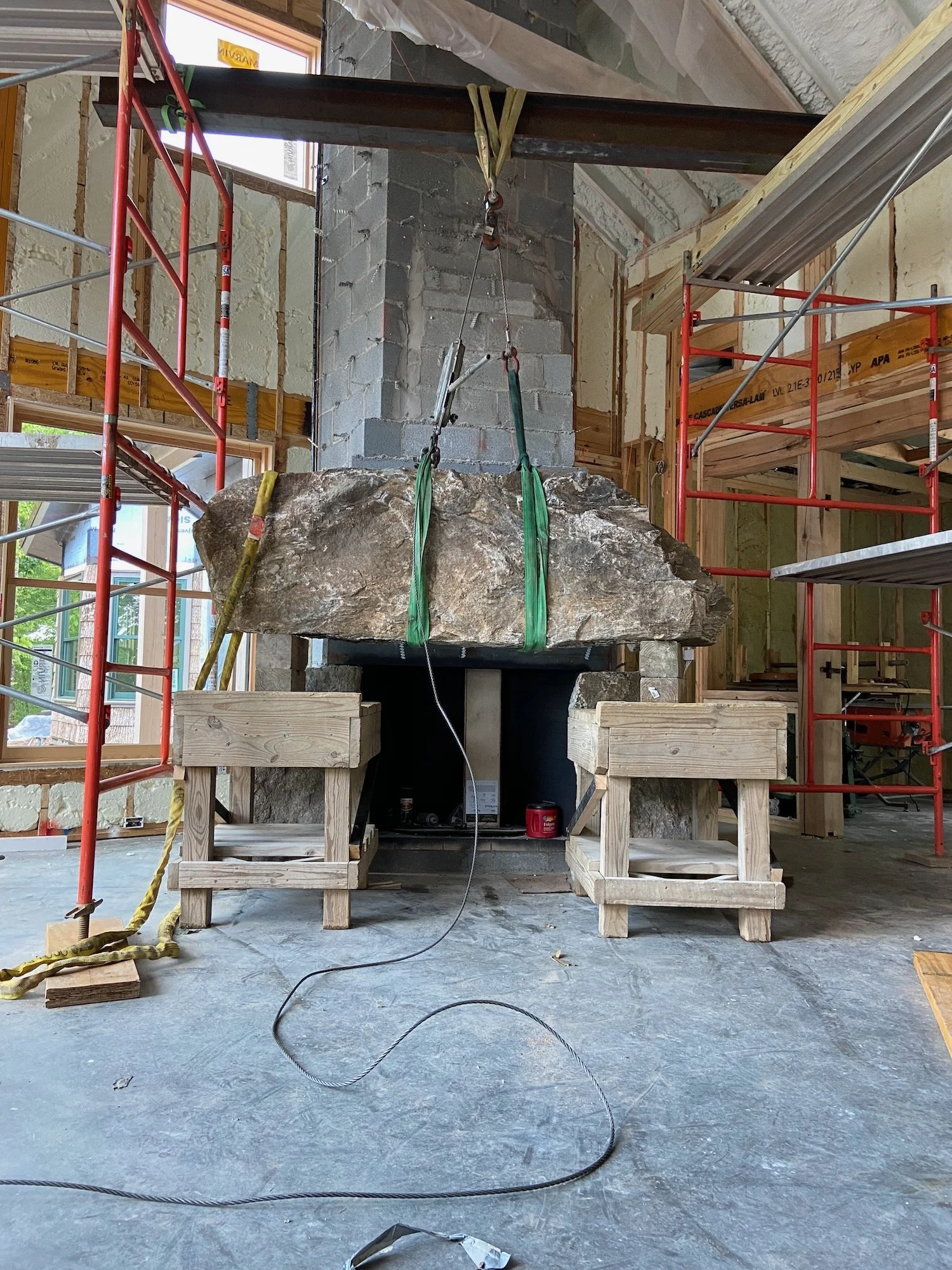 Setting the lintel of a massive fireplace.