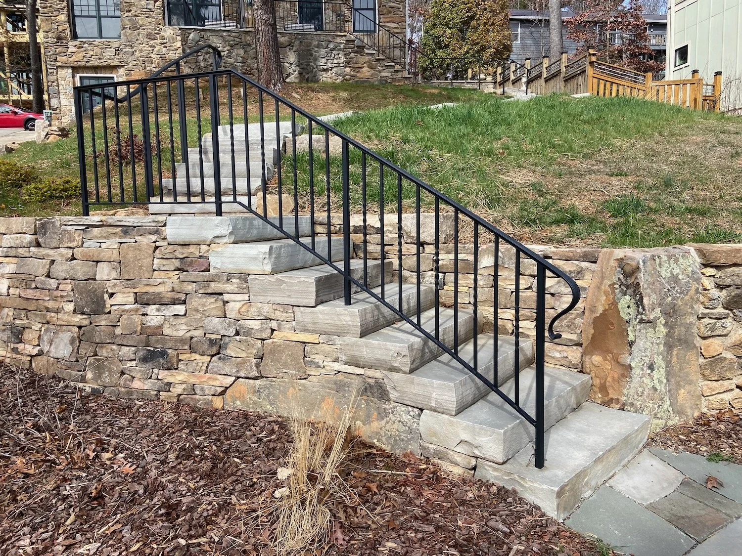 Slabs of gray Tennessee sandstone integrate into this retaining wall, North Asheville