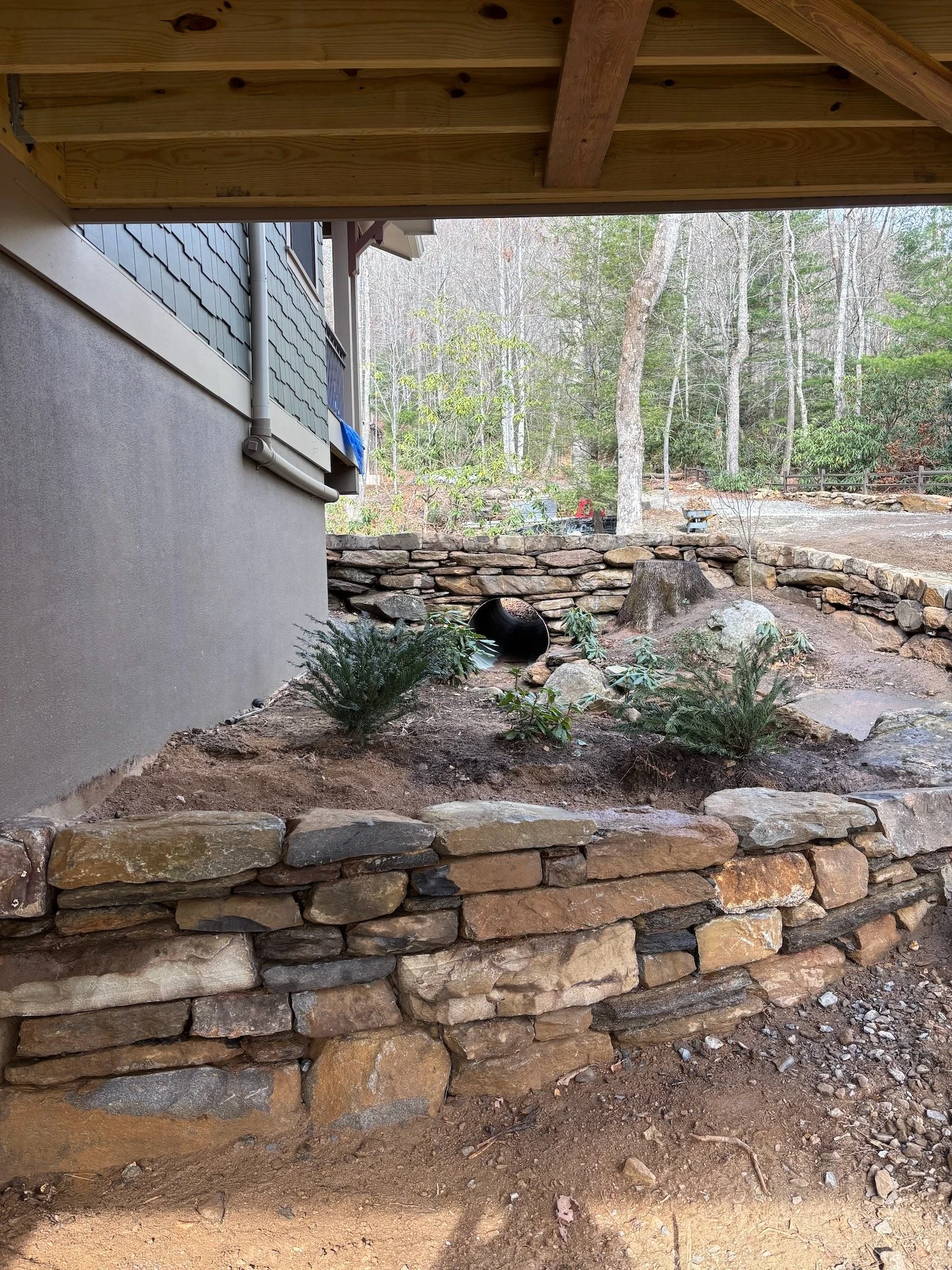 A rustic drystone wall repairs a hurricane damaged drainage creek in Black Mountain