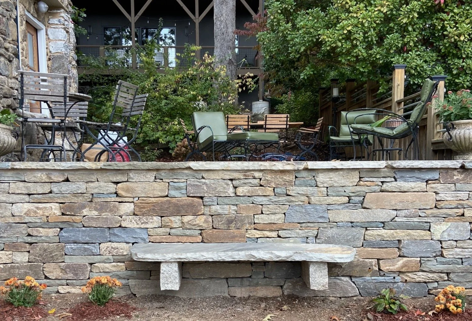 A drystone wall features a stone bench supported by cantilevered chunks of granite