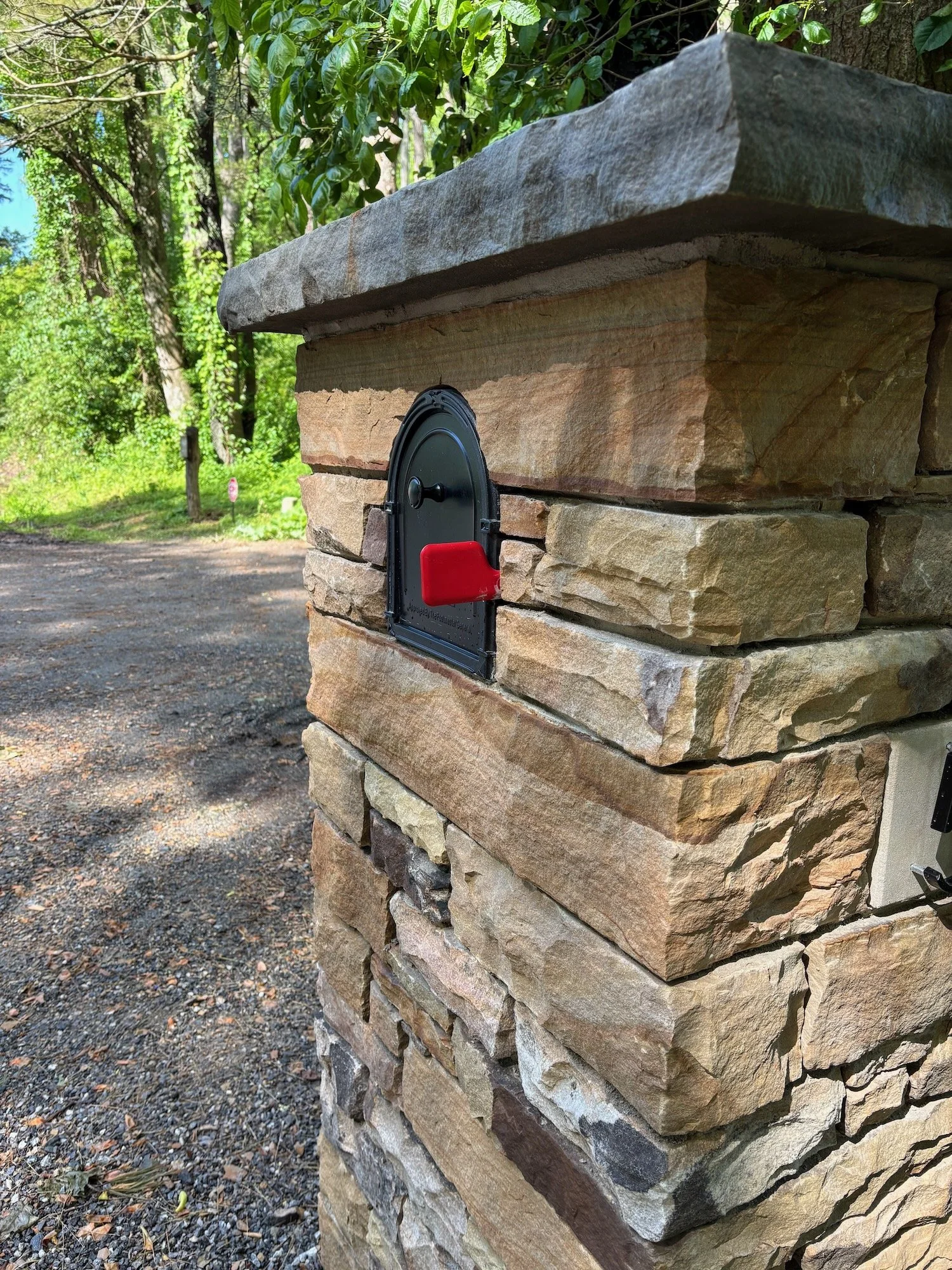I don't like it when they put the little flag on the stonework. It looks silly. We modify the mailbox so the flag can slide out from next to the box.