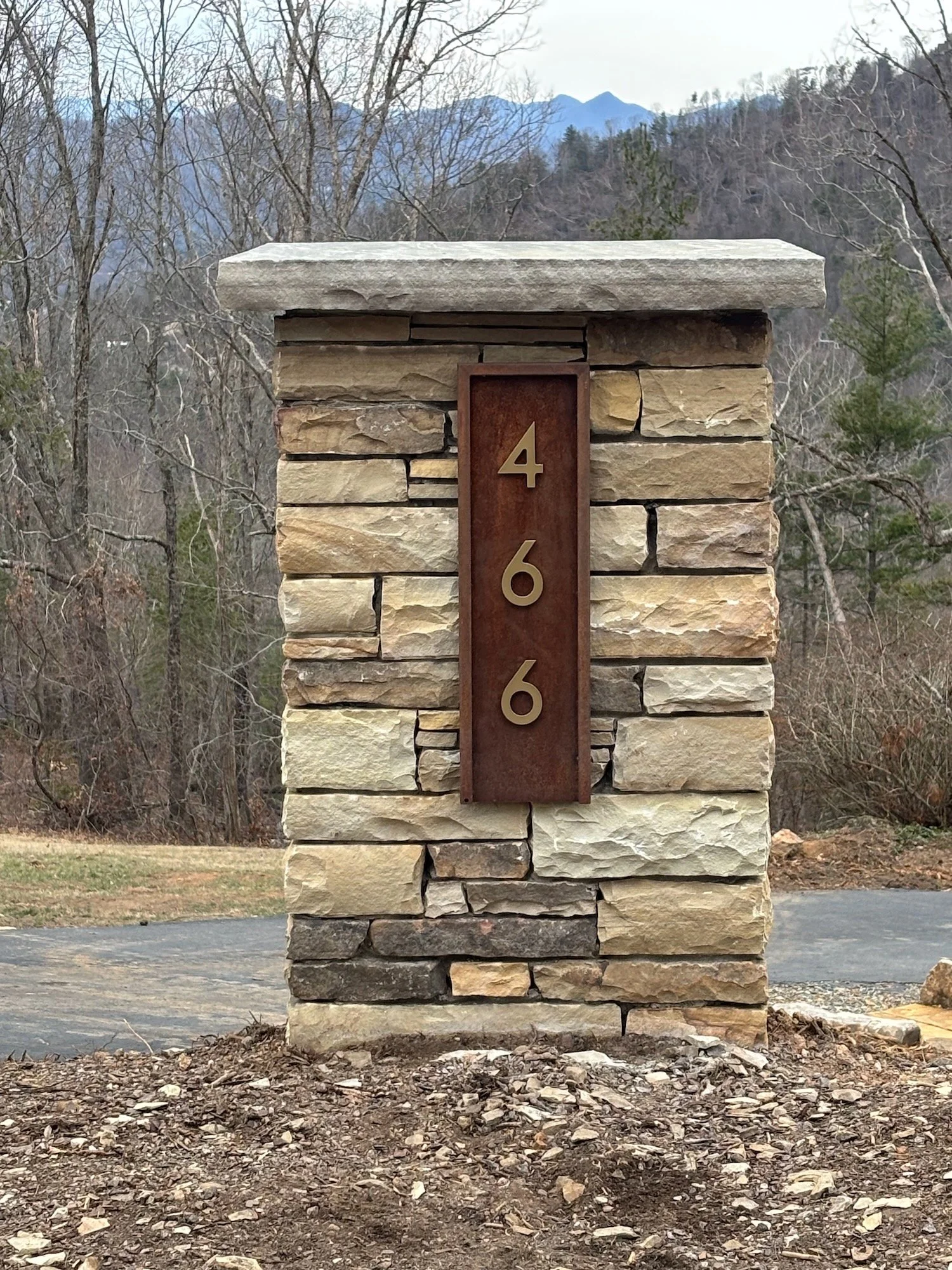 Metal number plate mounted to face of column.