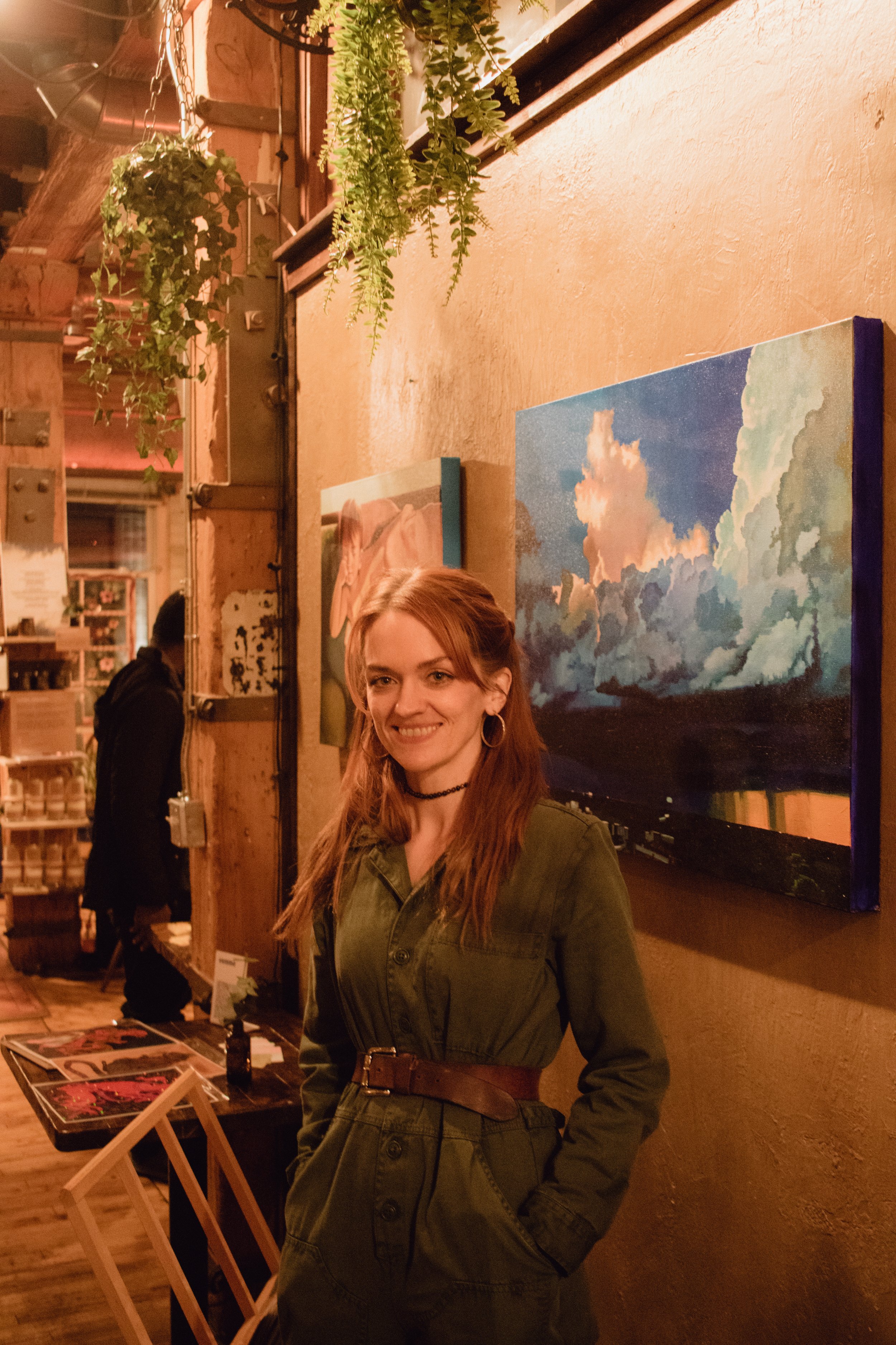  Artist  Kimberly Burnett  stands in front of her paintings in  Glassnote Candle Bar  for Hygge: A Pop Up Gallery, curated by Milwaukee artist, Lauren Marie Nitka. 