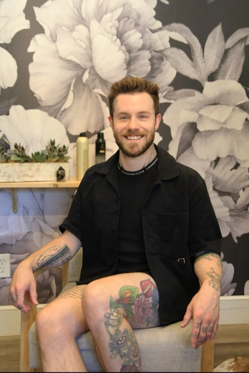 Portrait of Christopher Vogl sitting in a chair at Frequency Collective salon in Edmonds, WA.