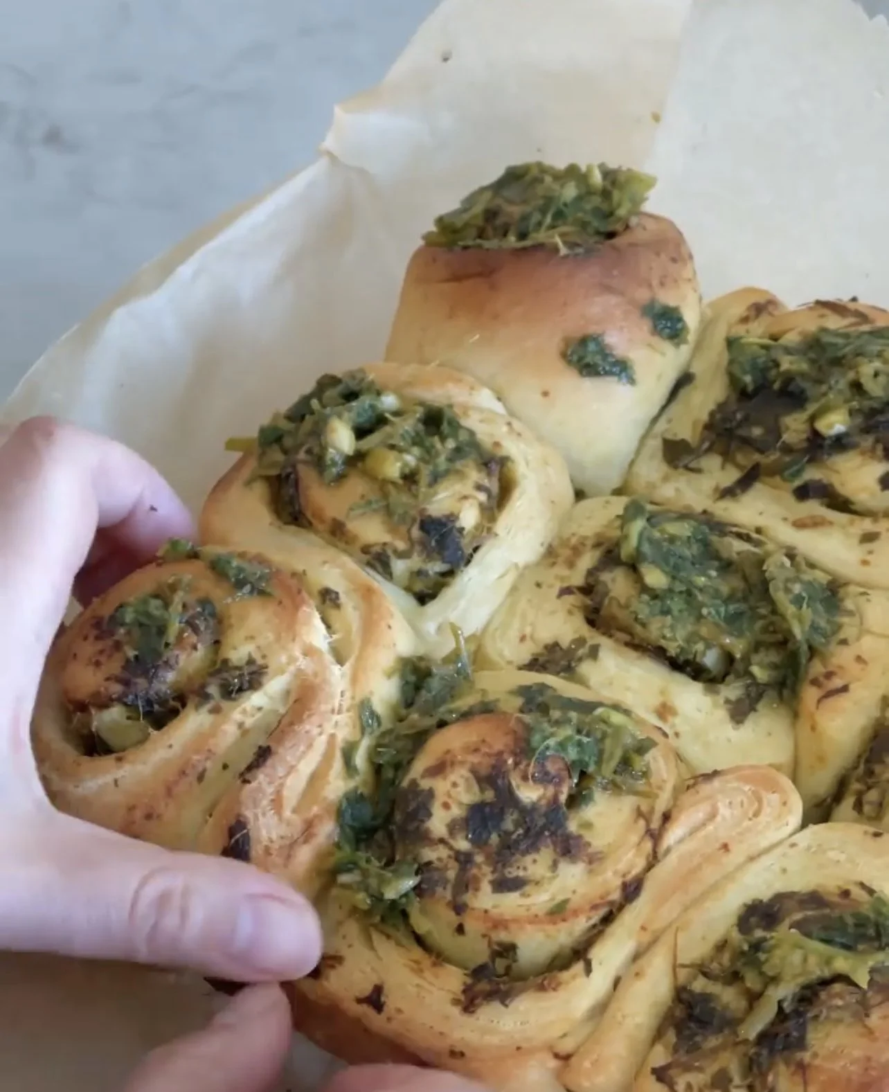 miso garlic pesto milk bread buns with hand reaching for a roll