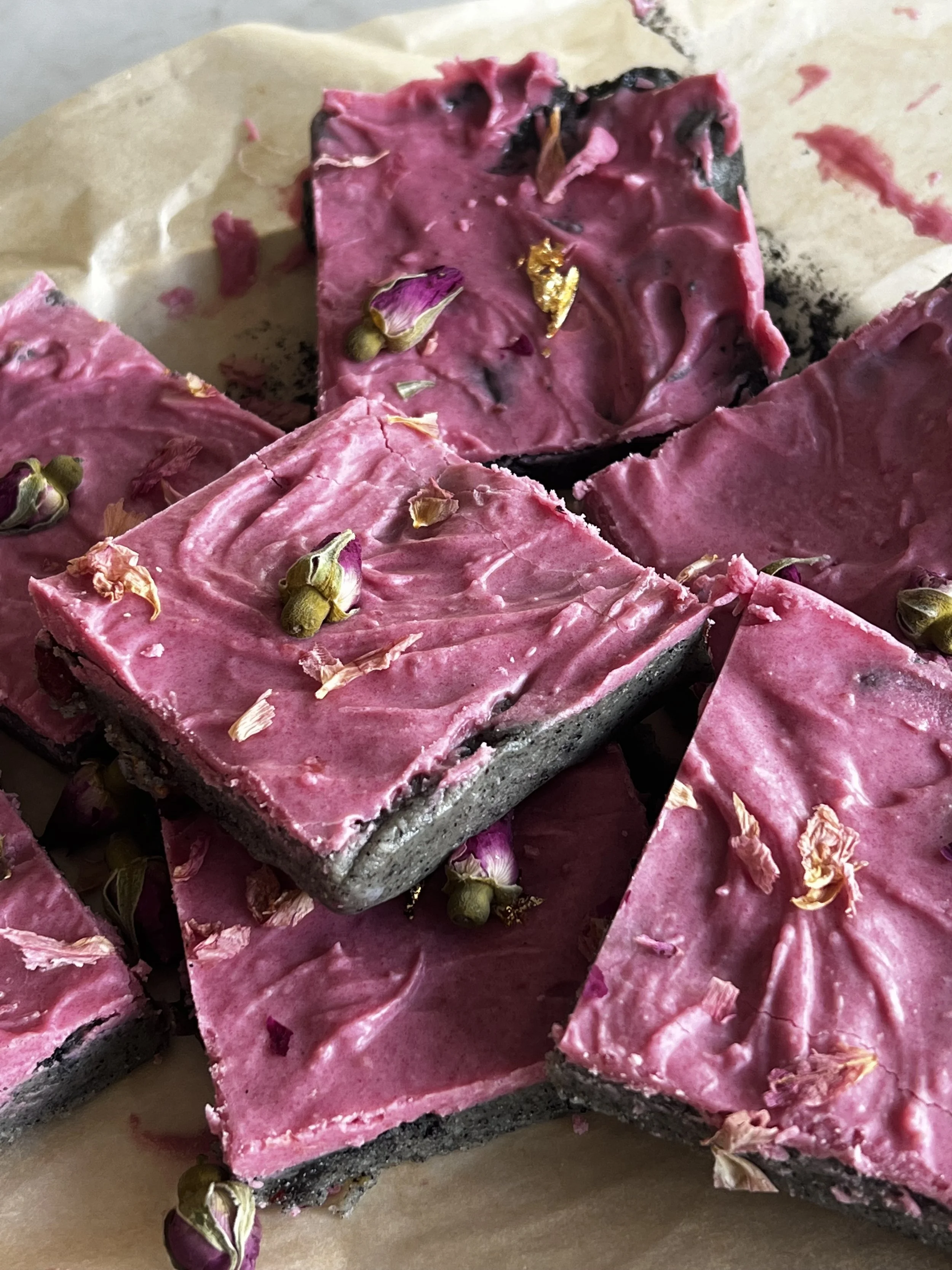 black pink no bake brownies laid on brown parchment paper