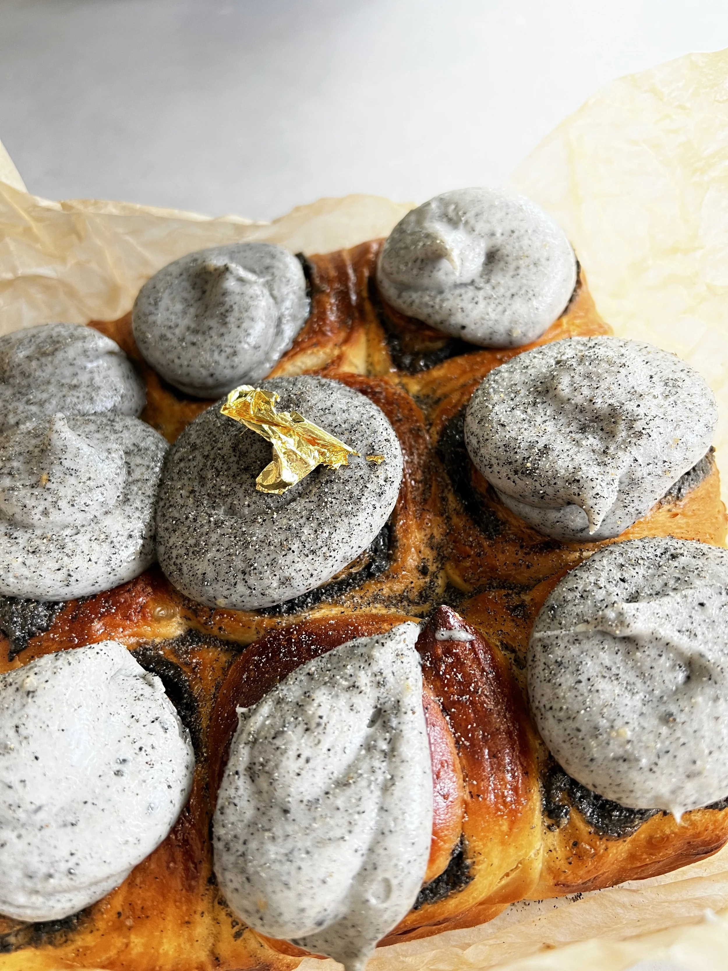 black sesame cardamom rolls on brown parchment paper