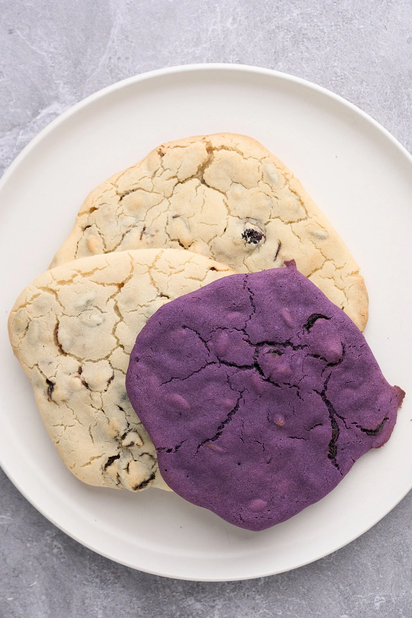 2 white and 1 purple mochi cookie laid down on white plate