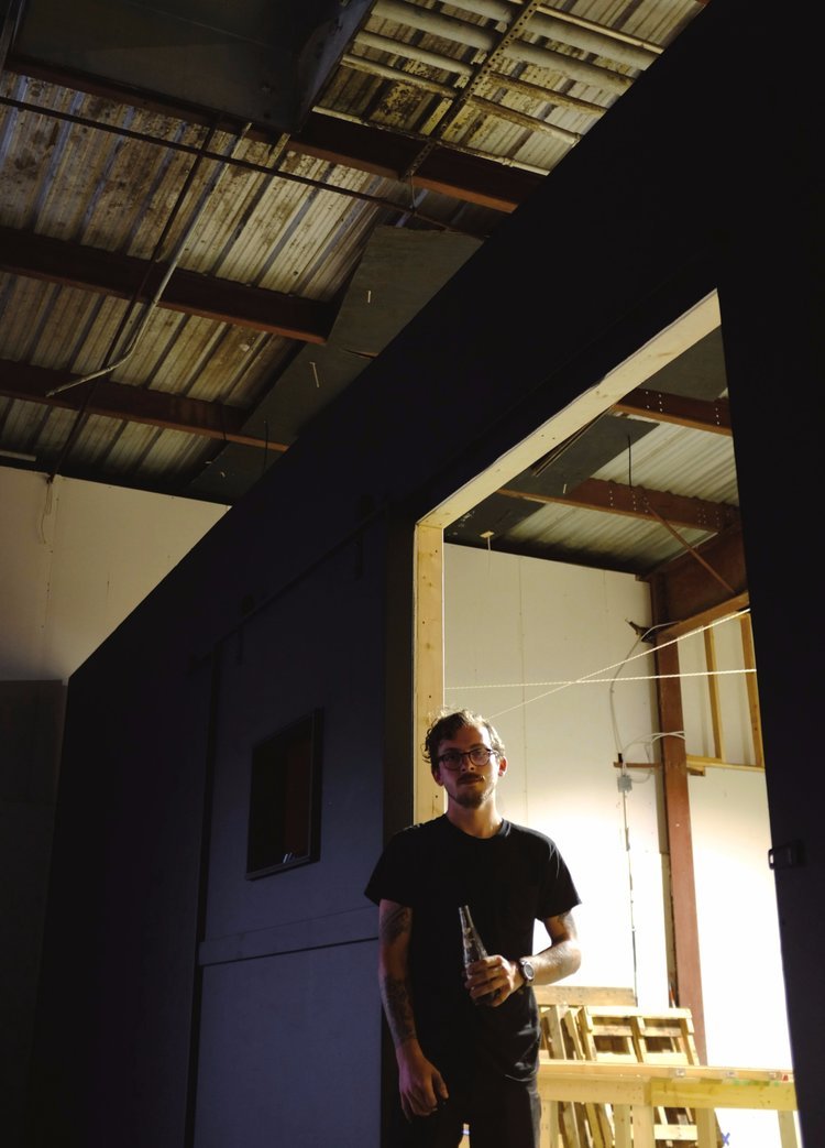 MASON BOVENDER, THE DESIGNER AND BUILDER BEHIND A CREATIVE COMPANY CALLED NINEPOUND, STANDS AT THE ENTRANCE OF HIS WORKSHOP SPACE AT THE BAKERY.