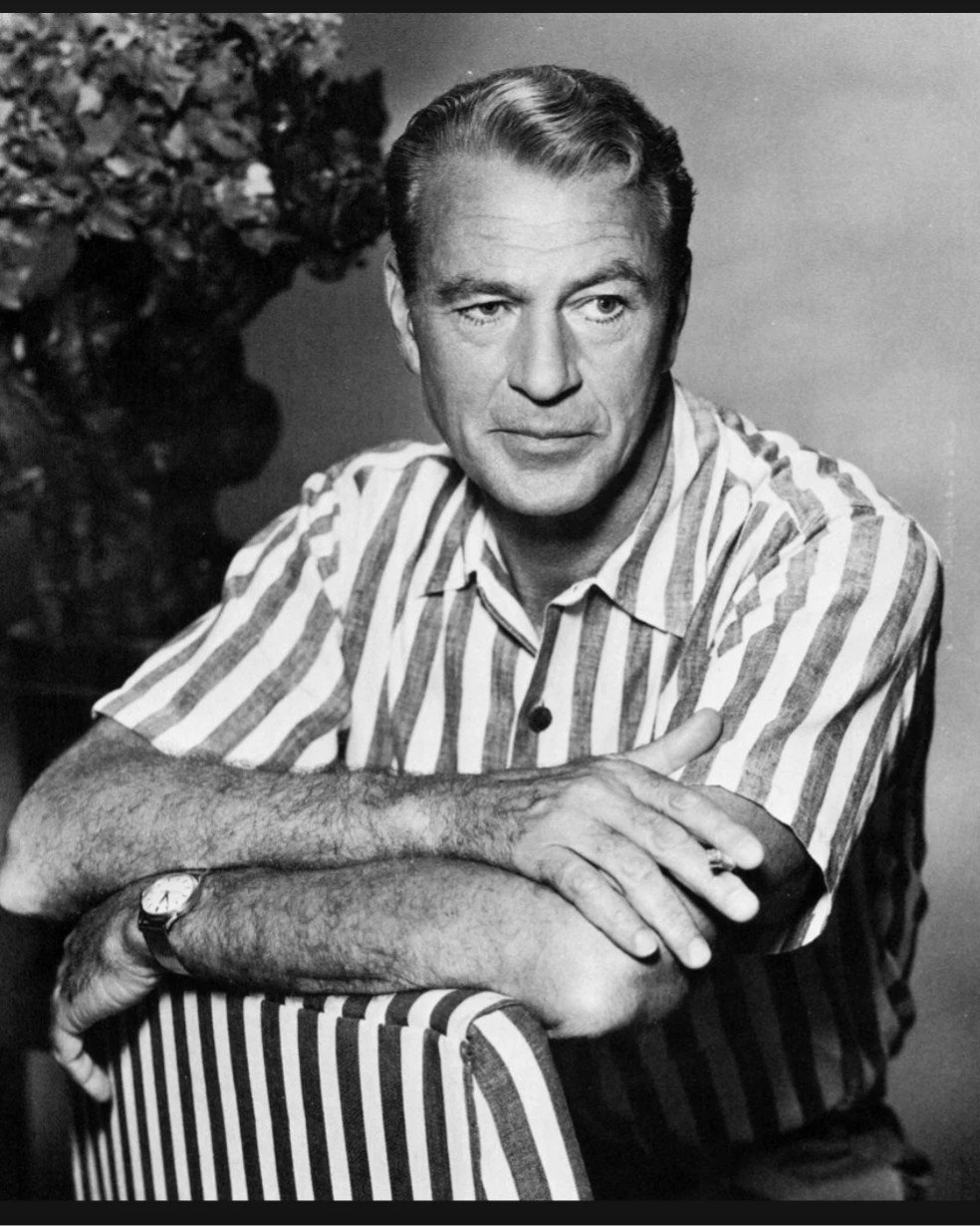 Let's turn back the hands of time and bask in the timeless charm of Gary Cooper's classic headshot! 🕰️📸 In this captivating throwback, Cooper exudes effortless sophistication as he strikes a pose in a stylish striped shirt, seated on a vintage chai