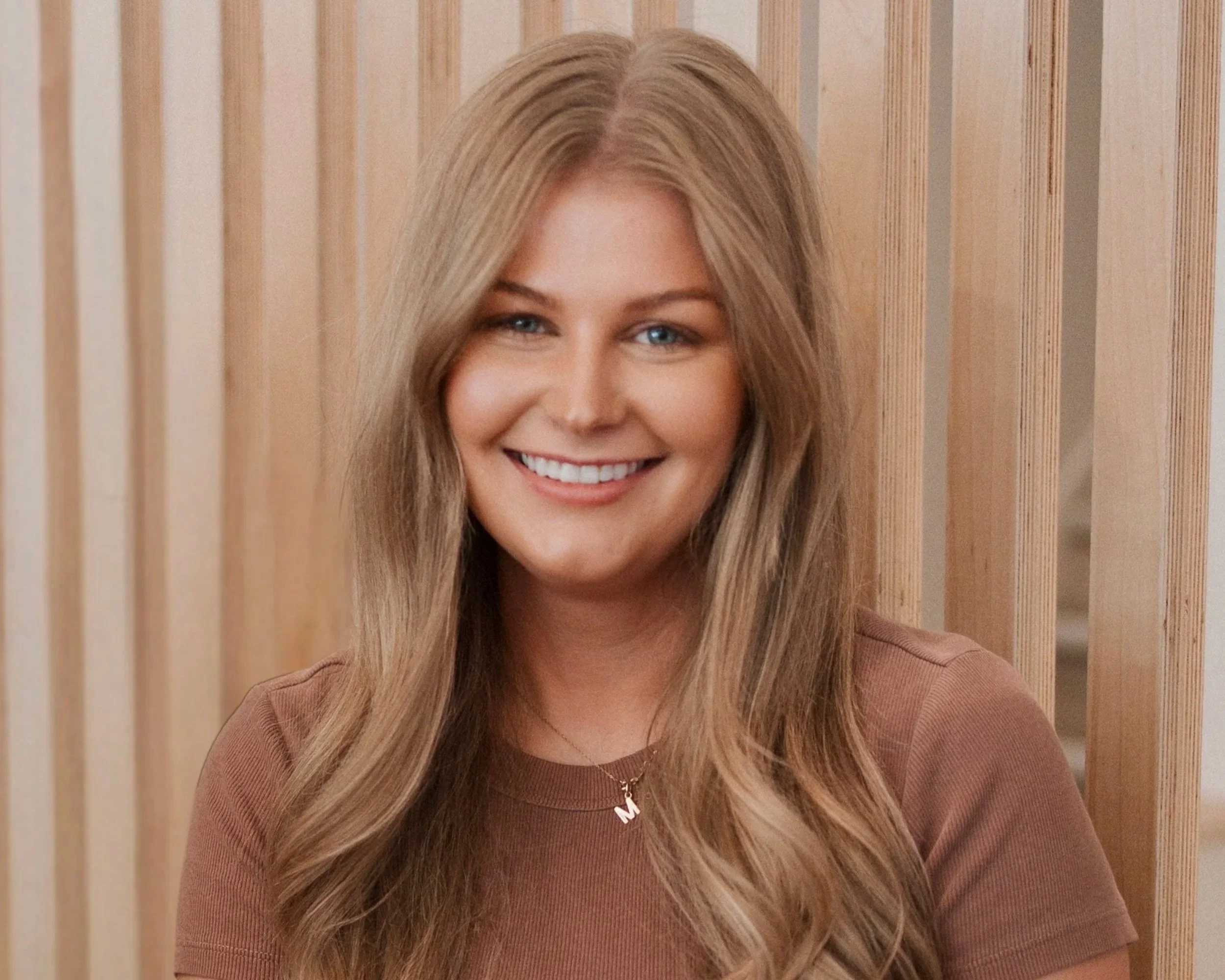 Smiling  woman in grey shirt.